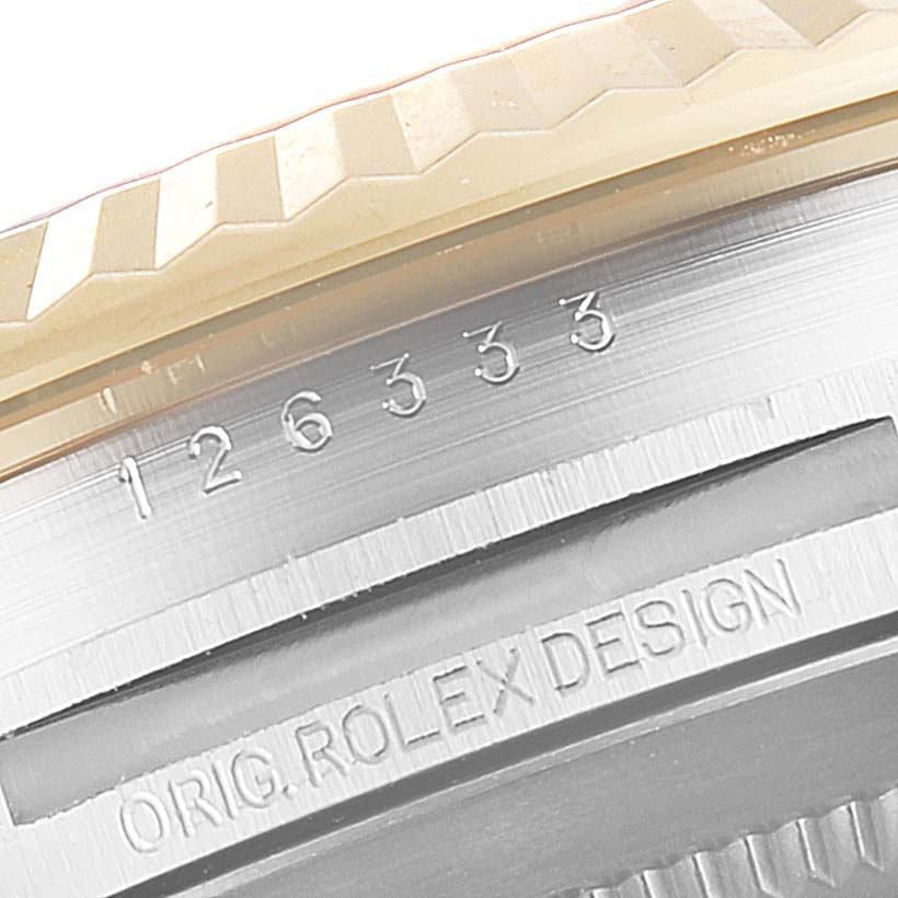 This close-up shows the engravings and textured bezel of a Rolex Datejust 41 126333 Men's Steel and Gold (two tone) White Dial 126333 Men's Steel and Gold (two tone) White Dial watch.
