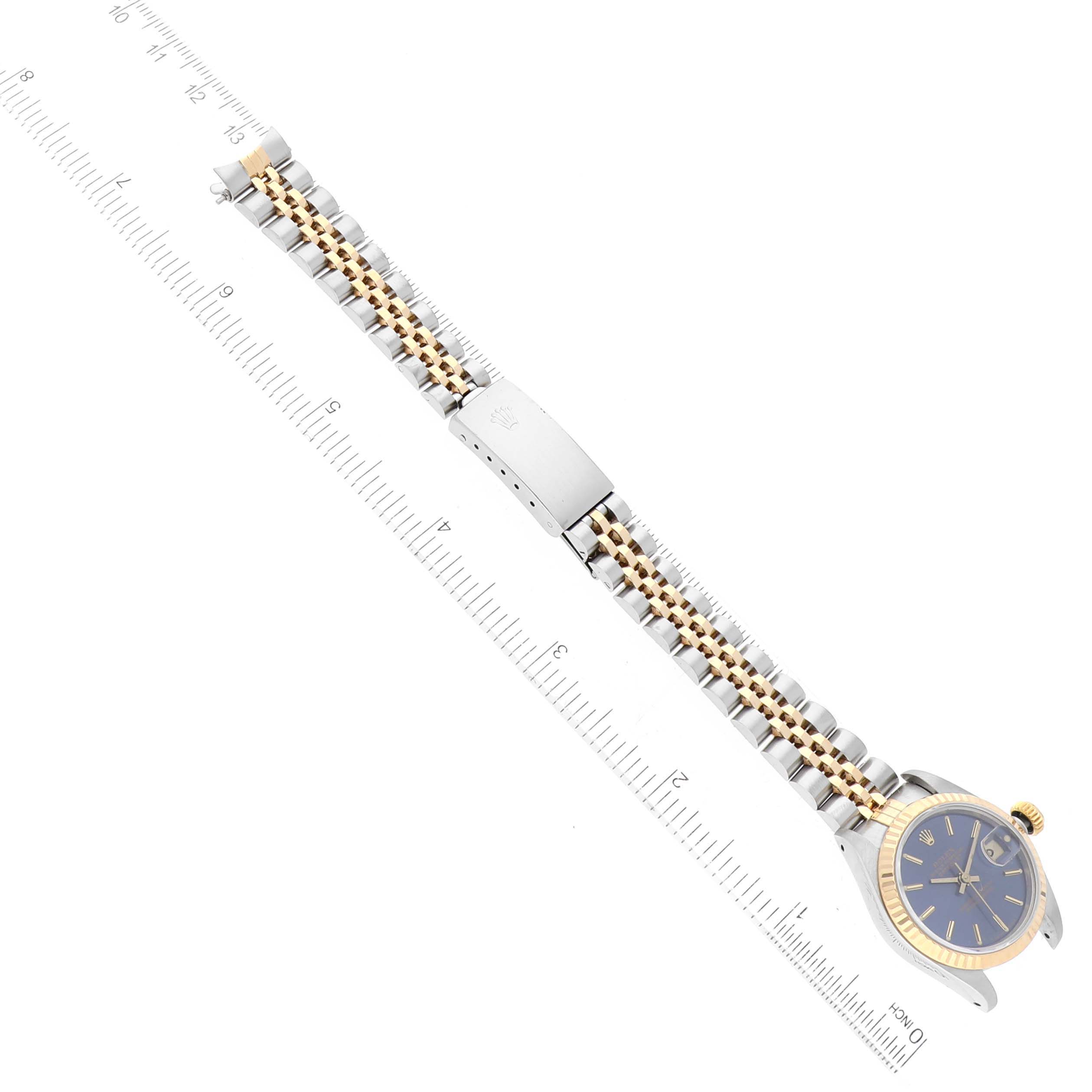 The image shows a side view of a Rolex Datejust 69173 Women's Steel and Gold (two tone) Blue Dial 69173 Women's Steel and Gold (two tone) Blue Dial watch, including the face, bracelet, and clasp, with a ruler for scale.