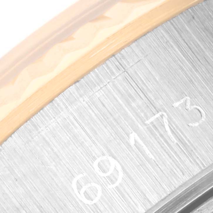 This close-up image depicts a partial view of the case and serial number of a Rolex Datejust 69173 Women's Steel and Gold (two tone) Blue Dial 69173 Women's Steel and Gold (two tone) Blue Dial watch.