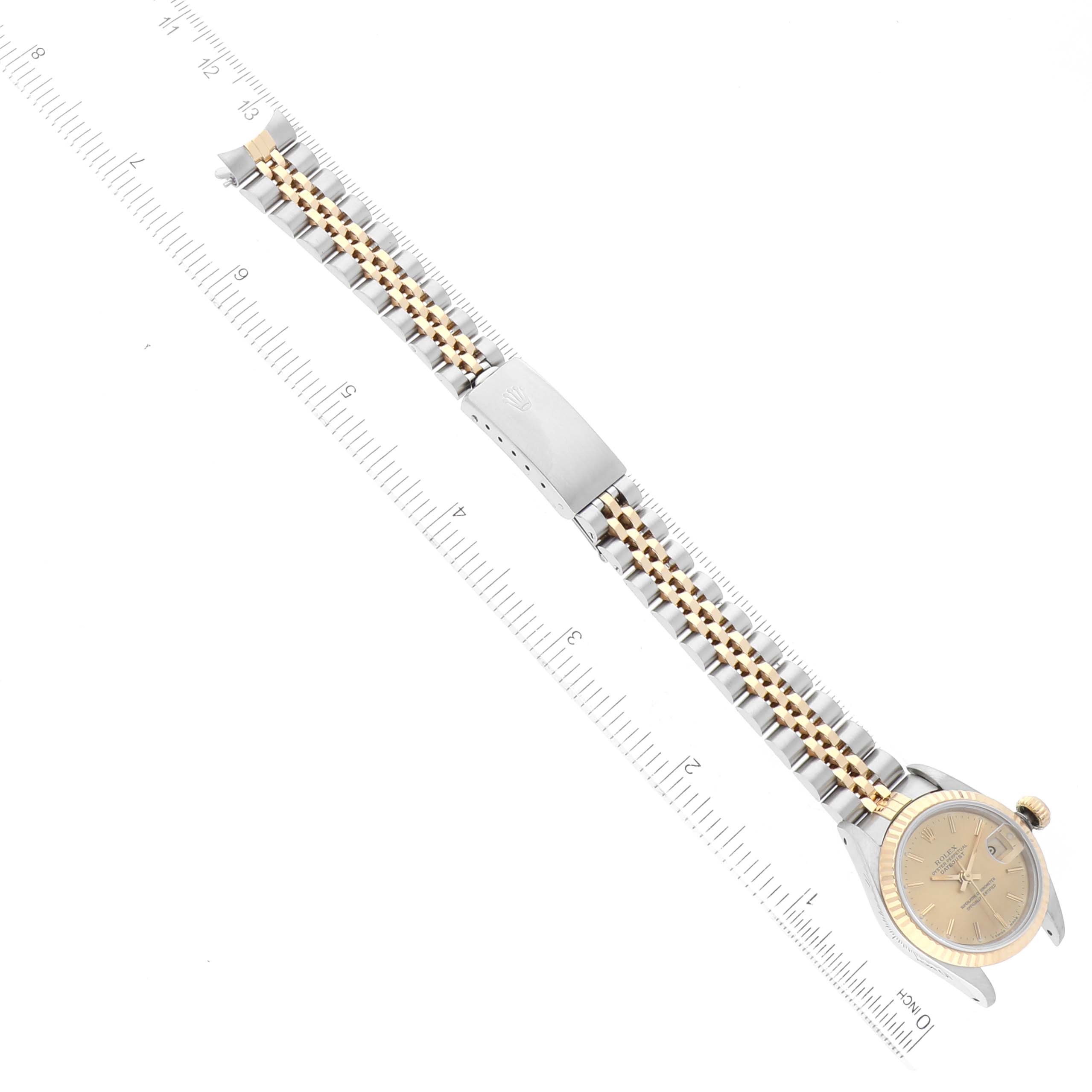 The image shows a top view of a Rolex Datejust 69173 Women's Steel and Gold (two tone) Champagne Dial 69173 Women's Steel and Gold (two tone) Champagne Dial watch, displaying the face, bezel, bracelet, and clasp next to a ruler.