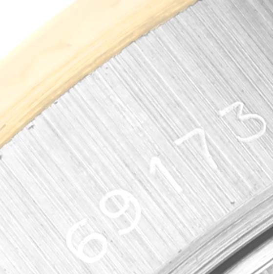 The image shows a close-up angled view of the serial number engraving on the side of a Rolex Datejust 69173 Women's Steel and Gold (two tone) Champagne Dial 69173 Women's Steel and Gold (two tone) Champagne Dial watch case.
