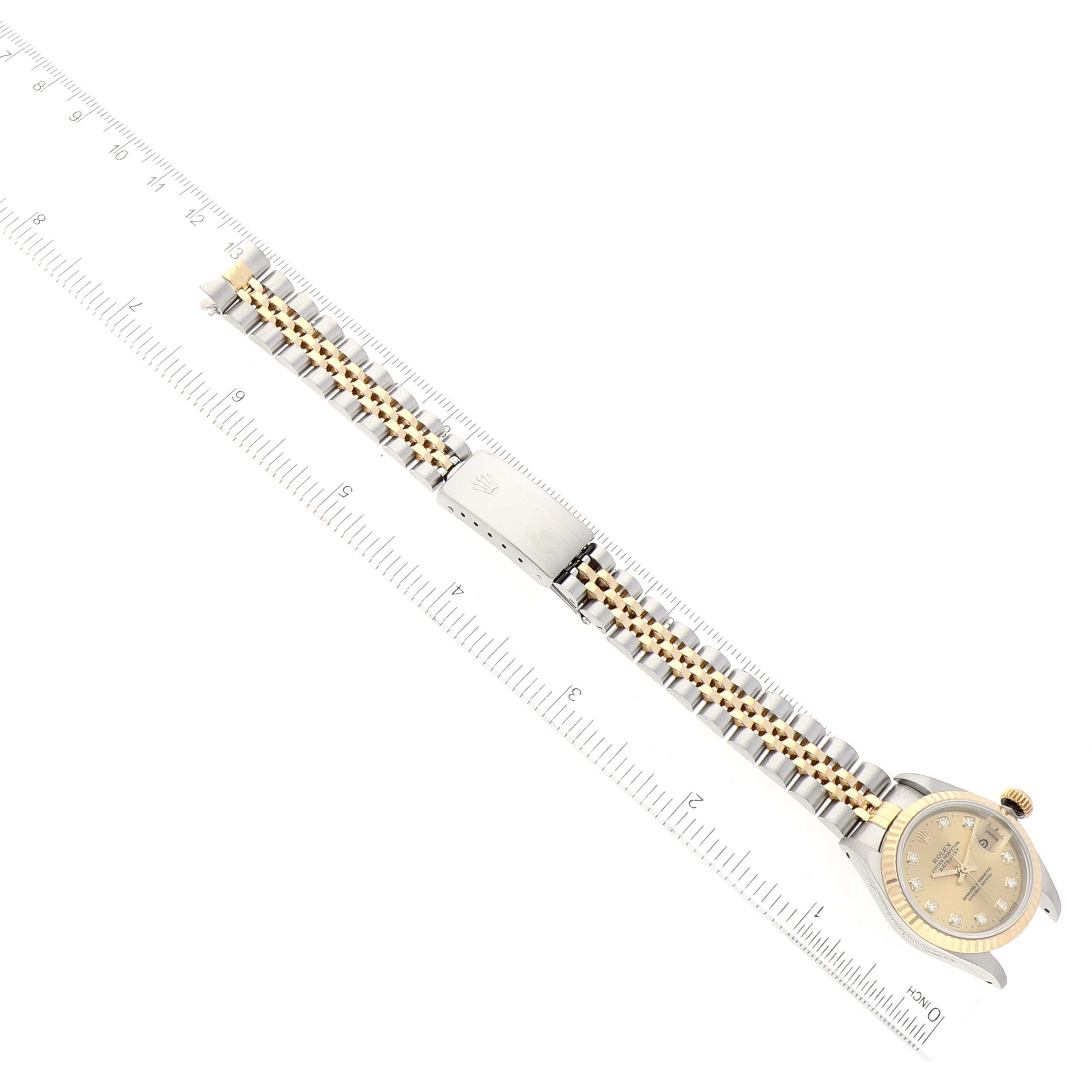This image shows a Rolex Datejust 69173G Women's Steel and Gold (two tone) Champagne Dial 69173G Women's Steel and Gold (two tone) Champagne Dial watch laid flat with its bracelet extended and measured by a ruler.