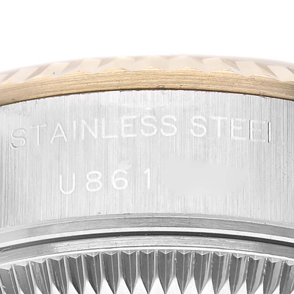 This image shows a close-up of the side of the case and the edge of the bezel on a Rolex Datejust 69173G Women's Steel and Gold (two tone) Champagne Dial 69173G Women's Steel and Gold (two tone) Champagne Dial watch, displaying the engraving and fluted bezel.