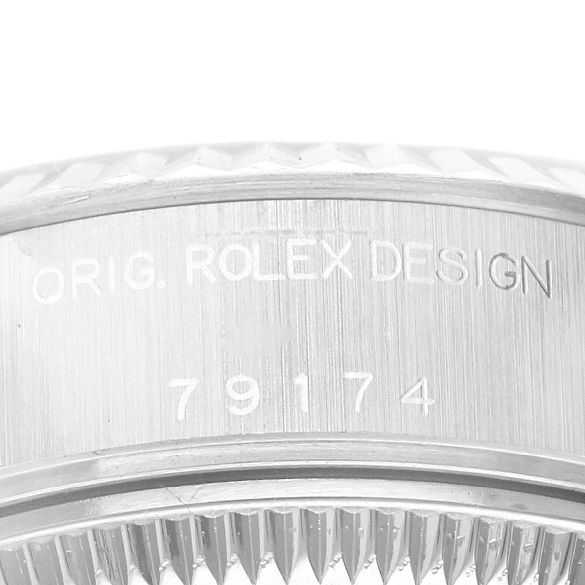 The image shows a close-up view of the bezel and inner case of a Rolex Datejust 79174 Women's Stainless Steel Pink Dial 79174 Women's Stainless Steel Pink Dial model, displaying the "ORIG. ROLEX DESIGN" engraving.