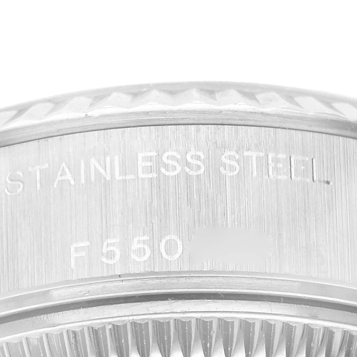 Close-up of the stainless steel side bezel of a Rolex Datejust 79174 Women's Stainless Steel Pink Dial 79174 Women's Stainless Steel Pink Dial watch, with etched serial and reference numbers visible.