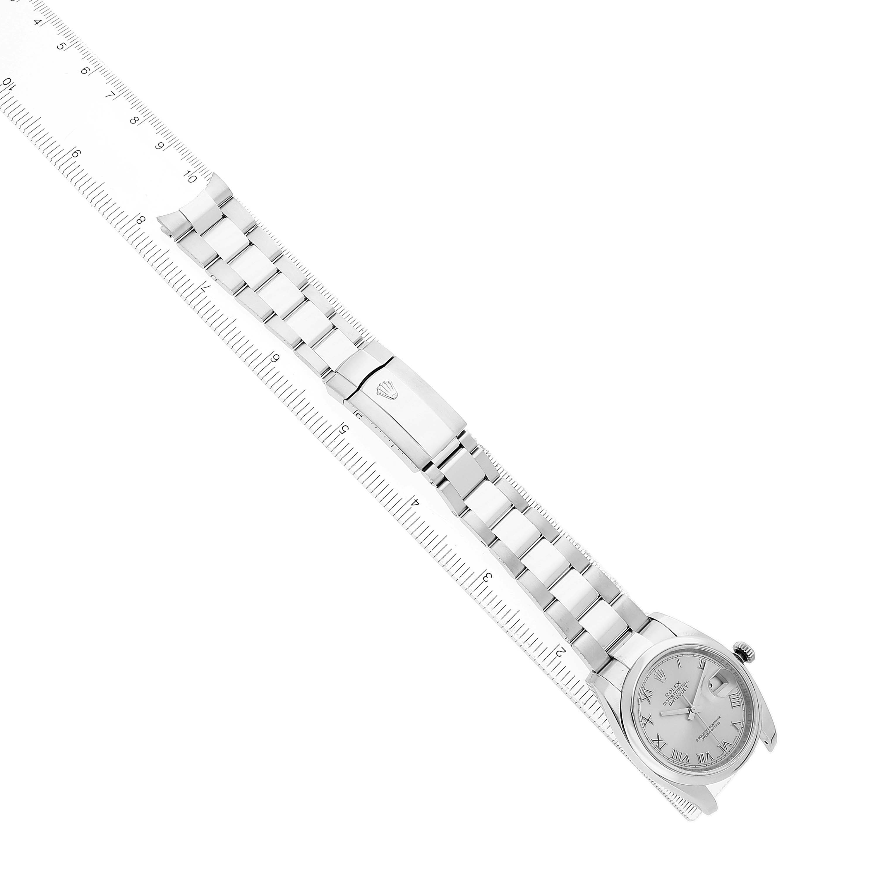 The Rolex Datejust 116200 Men's Stainless Steel Silver Dial watch is shown at a top-down angle, displaying the face, bracelet, and clasp with a ruler for scale.