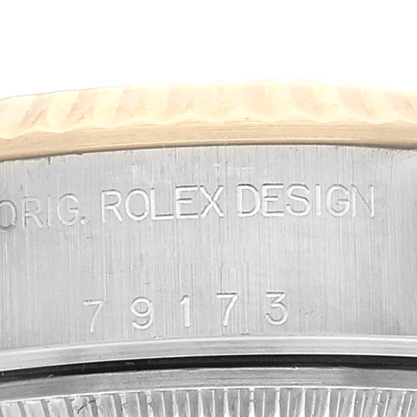 The image shows a close-up of the case side of a Rolex Datejust 79173 Women's Steel and Gold (two tone) Champagne Dial 79173 Women's Steel and Gold (two tone) Champagne Dial watch, highlighting the "ROLEX DESIGN" engraving and model number 79173.
