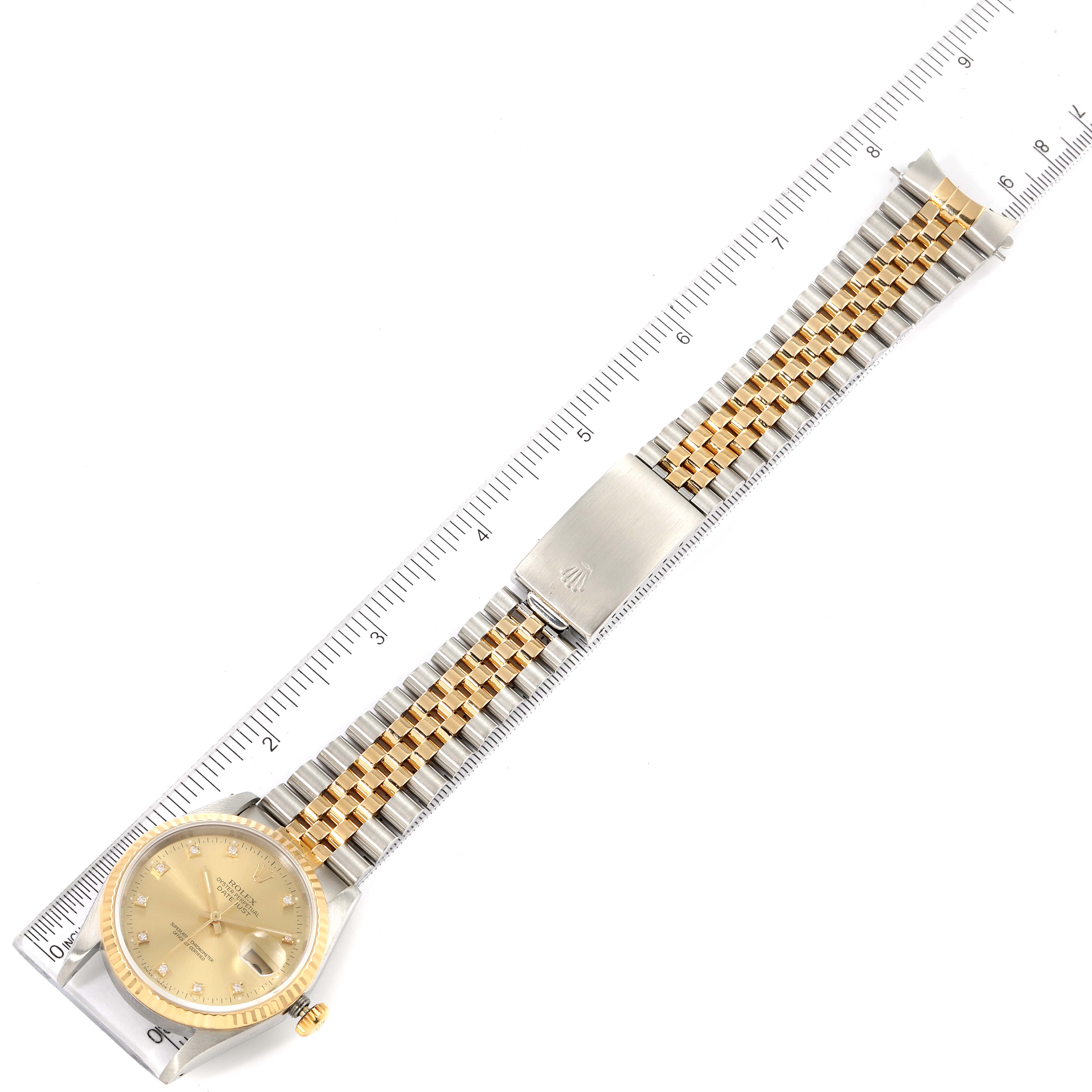 The image shows a top-down view of a Rolex Datejust 16233 Men's Steel and Gold (two tone) Champagne Dial 16233 Men's Steel and Gold (two tone) Champagne Dial watch, displaying the face, bezel, and bracelet fully extended with a ruler for scale.