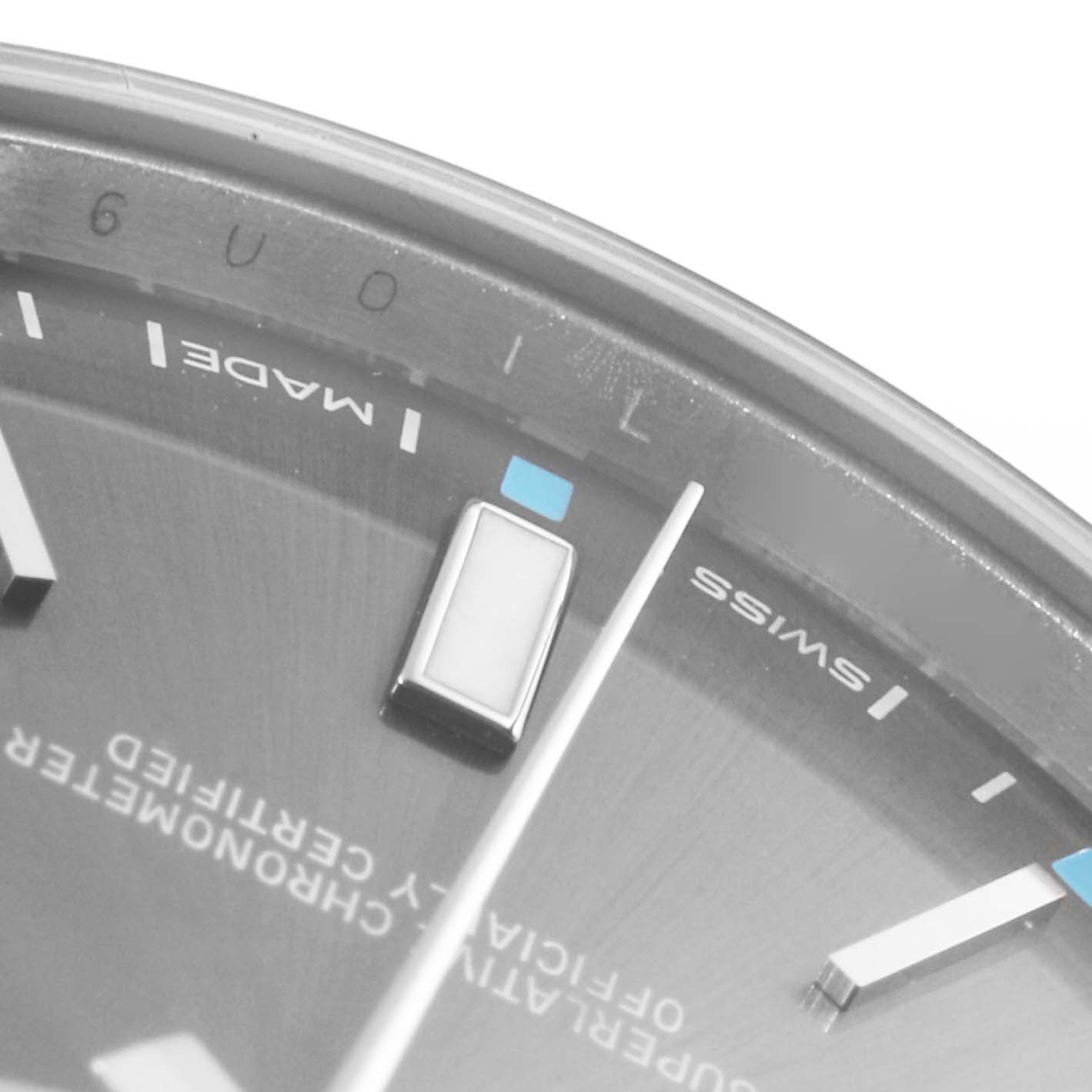 This close-up image shows the dial and markers of a Rolex Oyster Perpetual 114300 Men's Stainless Steel Grey Dial 114300 Men's Stainless Steel Grey Dial watch from an angle near the 30-minute mark.