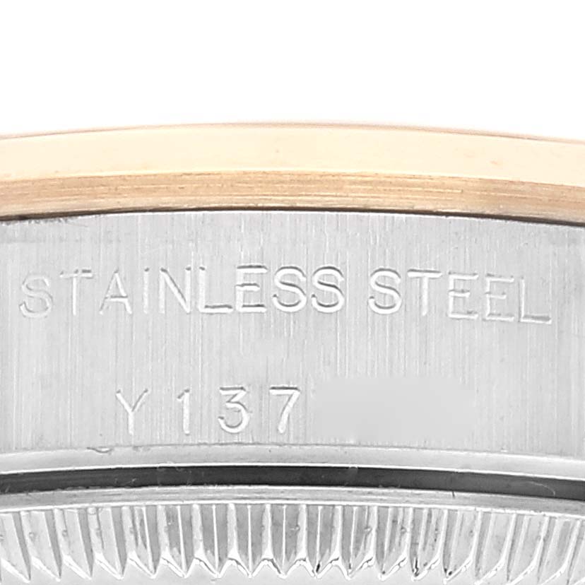 This close-up image shows a portion of the stainless steel case back with some engravings of a Rolex Oyster Perpetual 76183 Women's Steel and Gold (two tone) Grey Dial 76183 Women's Steel and Gold (two tone) Grey Dial watch.