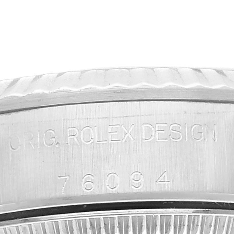 The image shows a close-up of the engraved case side of a Rolex Oyster Perpetual 76094 Women
s Stainless Steel Pink Dial 76094 Women
s Stainless Steel Pink Dial watch.
