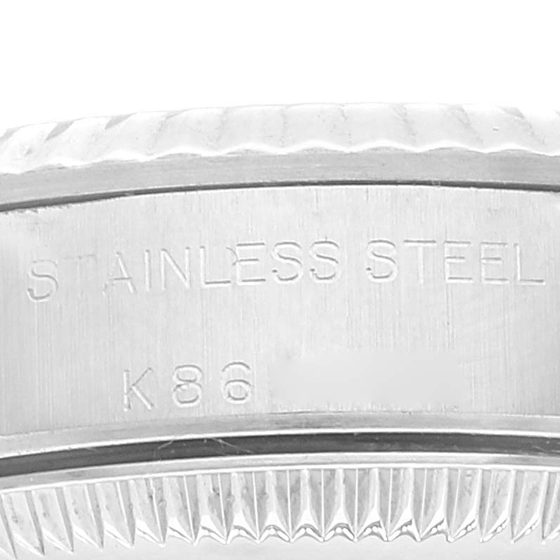 This close-up image shows part of the stainless steel case of a Rolex Oyster Perpetual 76094 Women
s Stainless Steel Pink Dial 76094 Women
s Stainless Steel Pink Dial watch.