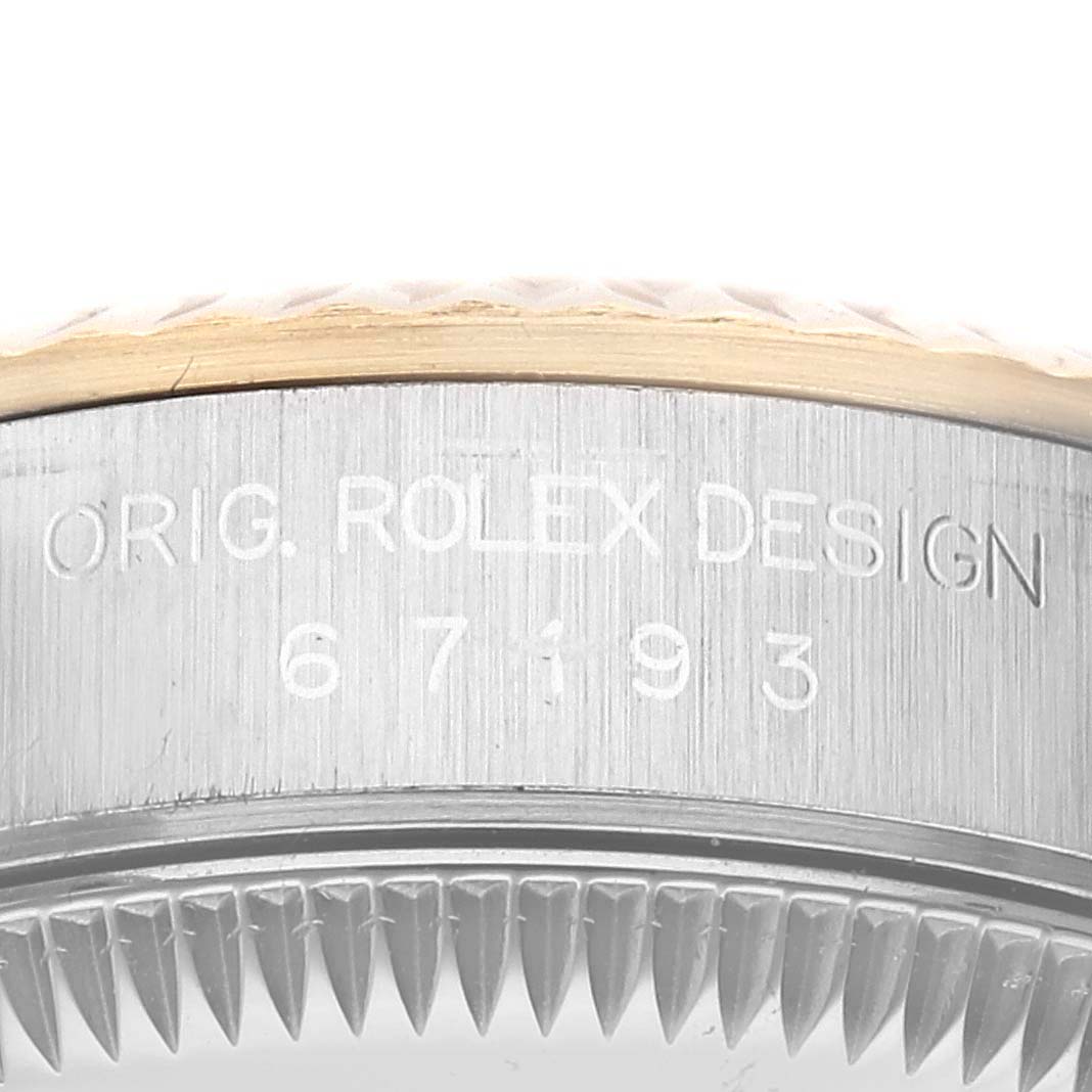 This image shows a close-up of the side case and bezel of the Rolex Oyster Perpetual 67193 Women's Steel and Gold (two tone) Champagne Dial 67193 Women's Steel and Gold (two tone) Champagne Dial watch, focusing on the engraved text.