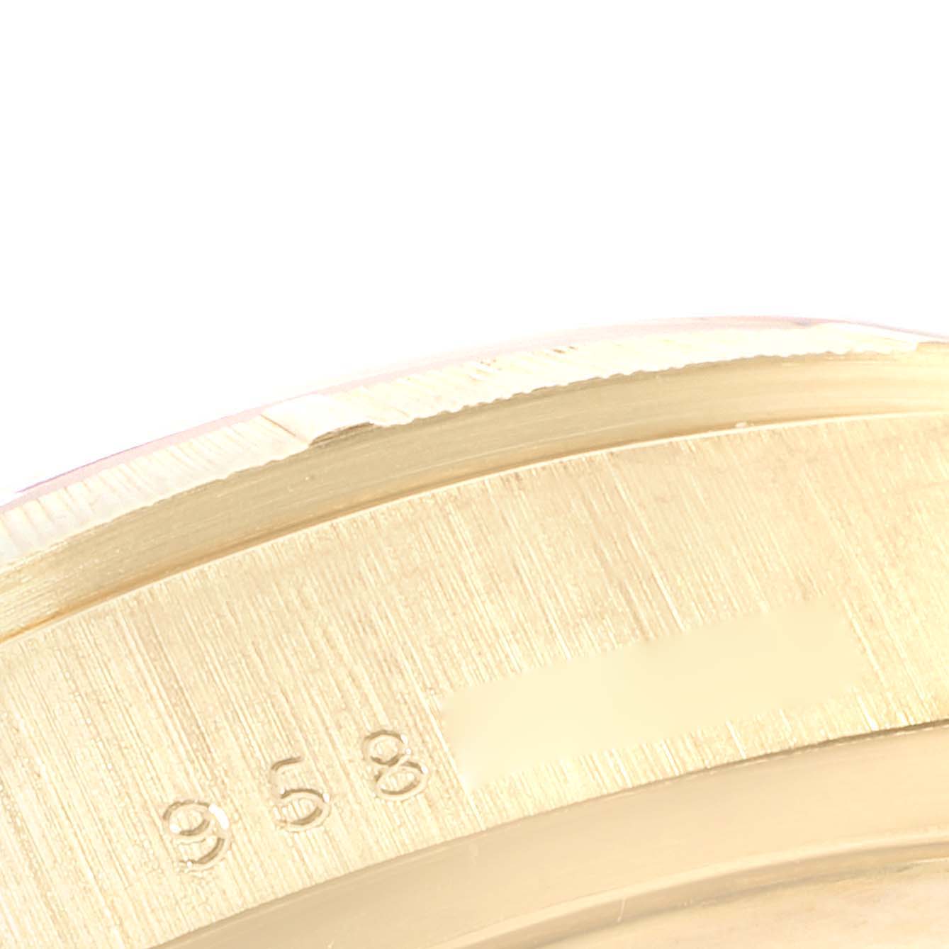This close-up image of the Rolex President 18078 Men's Yellow Gold Champagne Dial 18078 Men's Yellow Gold Champagne Dial model shows part of the watch casing with a number etched on it.