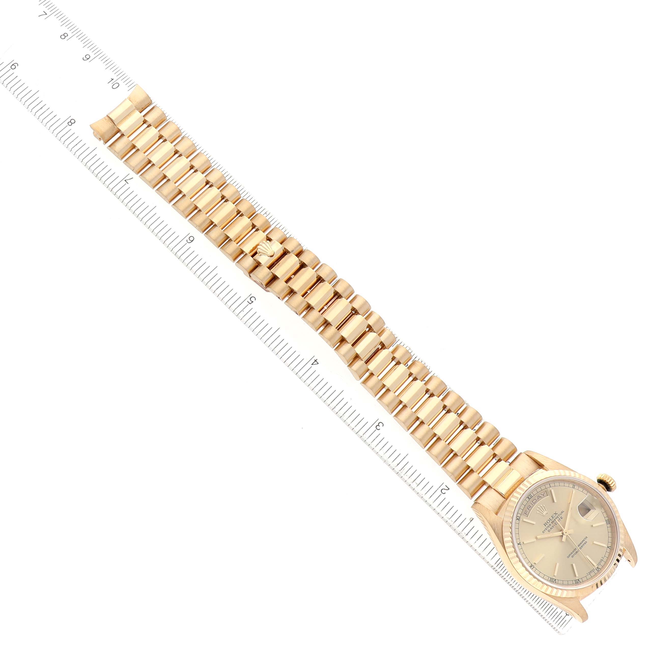 The image shows a Rolex President 18238 Men's Yellow Gold Champagne Dial watch, angled diagonally with the band extended alongside a ruler.