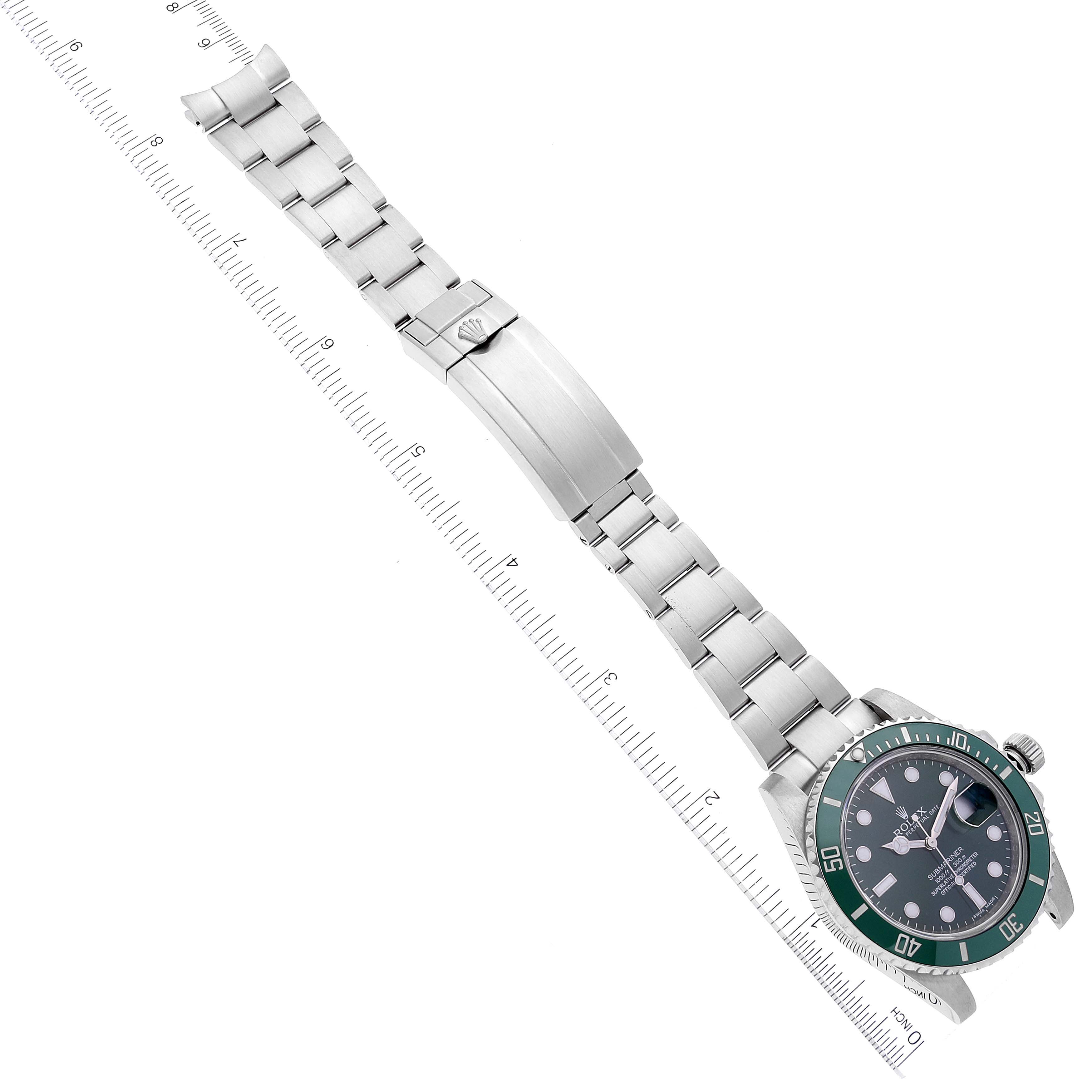 The image shows a Rolex Submariner 116610LV Men's Stainless Steel Green Dial 116610LV Men's Stainless Steel Green Dial watch at a flat angle, displaying its face, bezel, and bracelet laid next to a ruler.