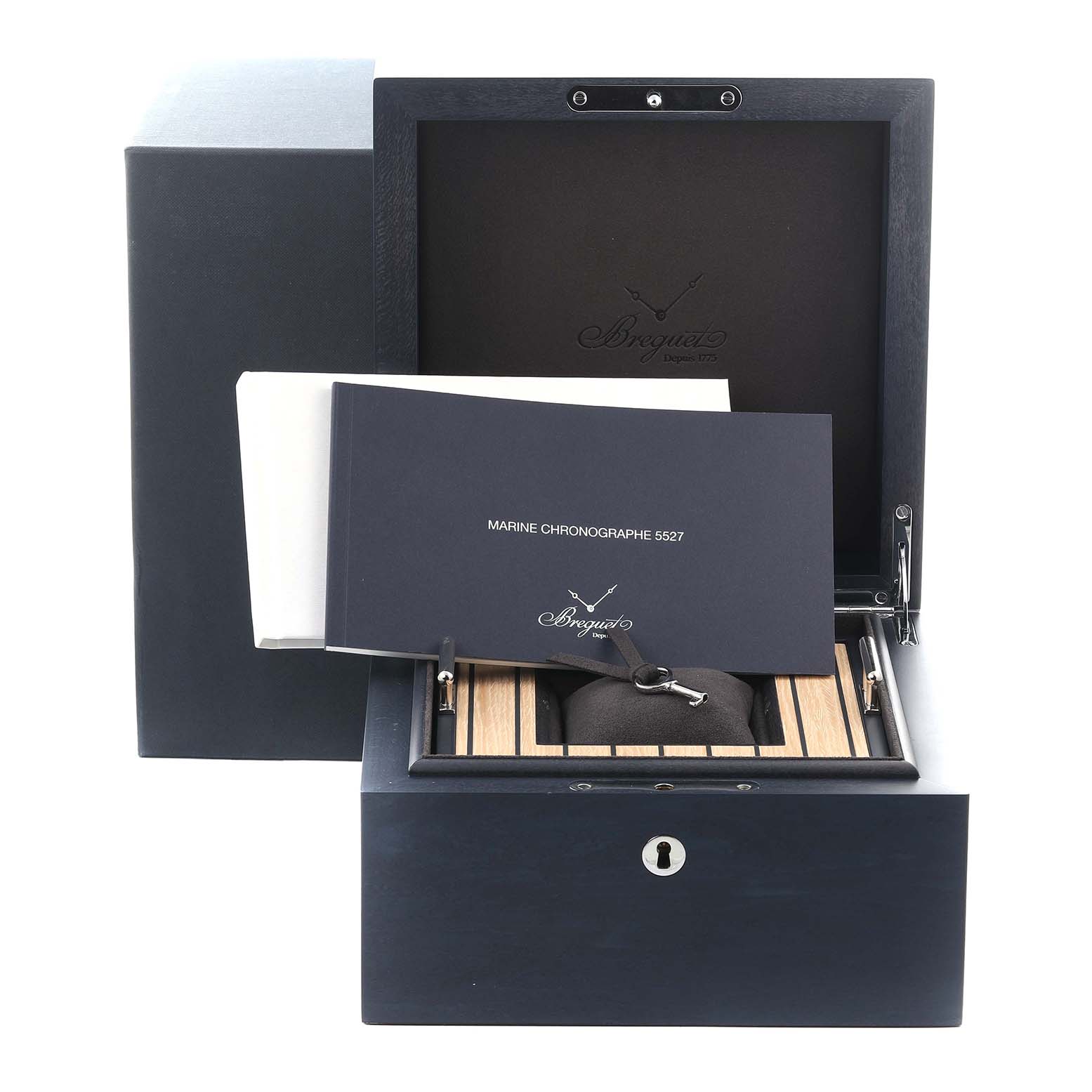 The image shows the Breguet Marine 5527BB/Y2/5WV Men's White Gold Blue Dial 5527BB/Y2/5WV Men's White Gold Blue Dial watch box and literature, with the inner box lid open displaying the manual and cushion.