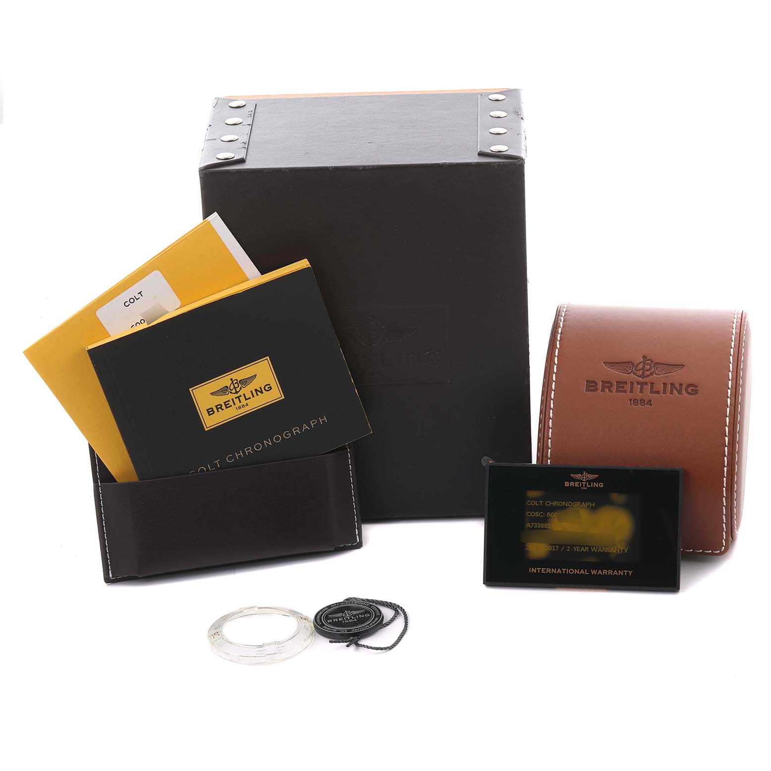 The image shows Breitling Colt A73388 Men
s Stainless Steel White Dial A73388 Men
s Stainless Steel White Dial watch accessories, including manuals, a black card with warranty info, a case, and packaging.