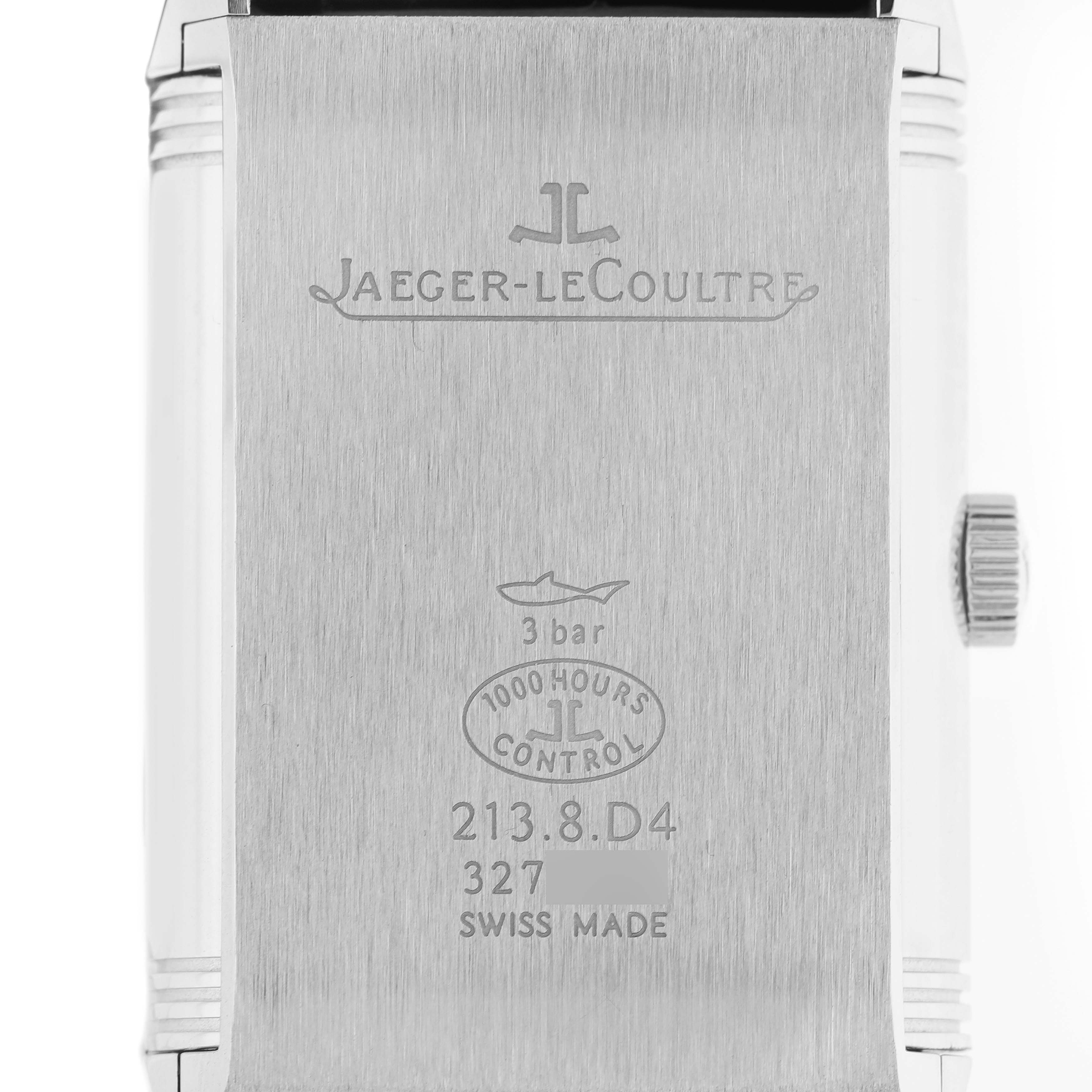 The image shows the back of a Jaeger-LeCoultre Reverso, featuring engravings and the crown on the side.