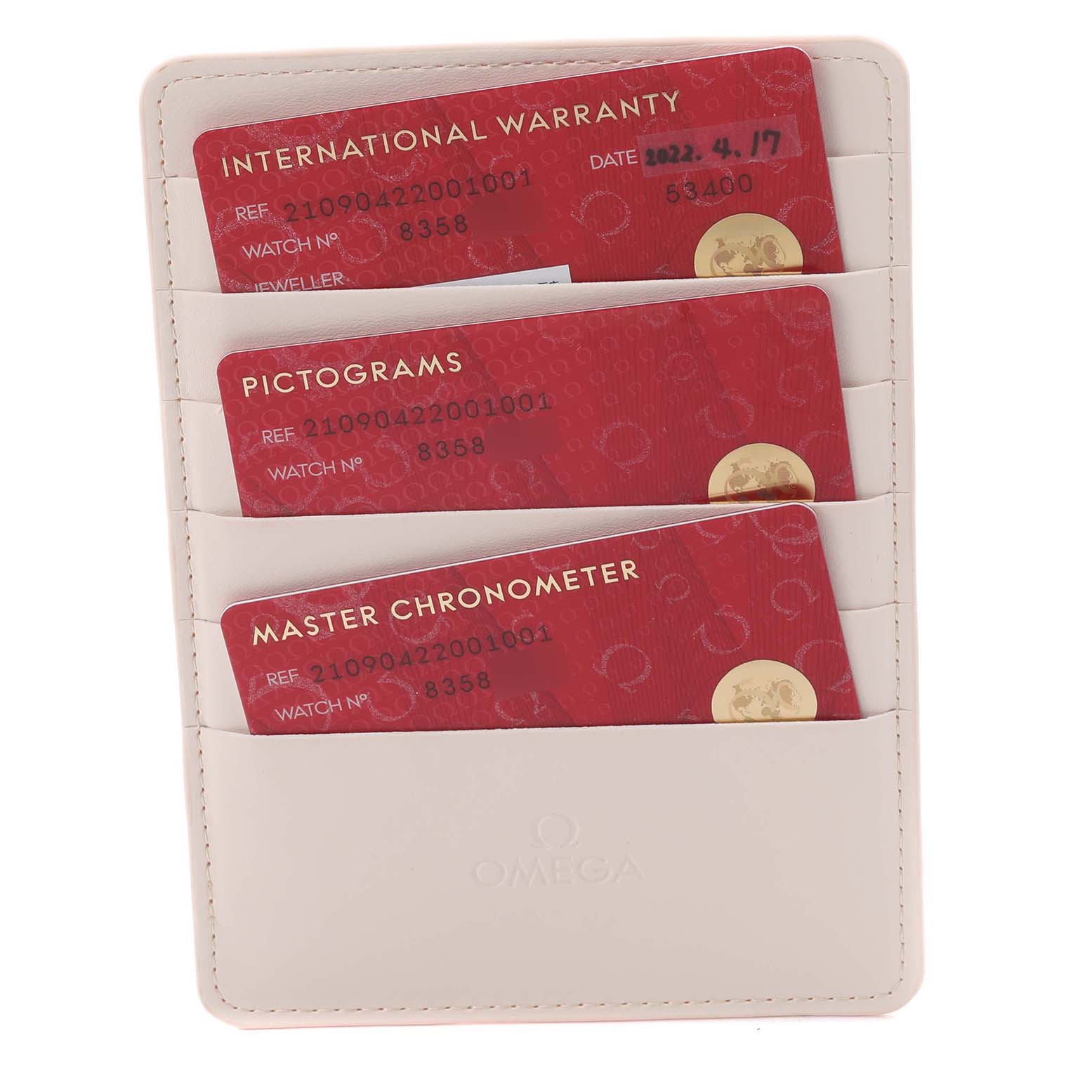 The image shows warranty cards in a beige holder for the Omega Seamaster 210.90.42.20.01.001 Men's Titanium Brown Dial 210.90.42.20.01.001 Men's Titanium Brown Dial watch.