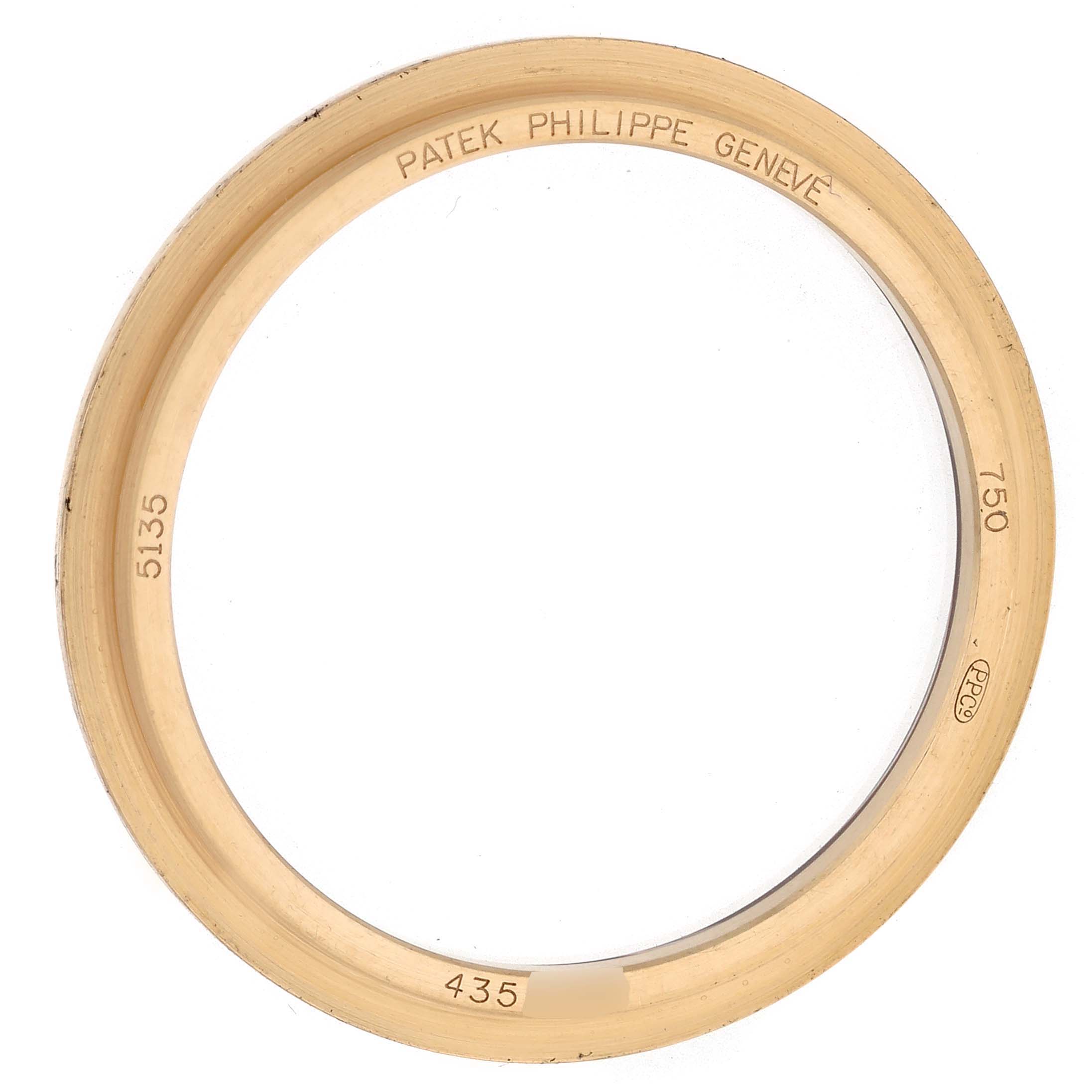 This image shows a gold bezel for a Patek Philippe Gondolo 5135J-001 Men's Yellow Gold Silver Dial 5135J-001 Men's Yellow Gold Silver Dial watch, viewed from a top angle with engravings visible.
