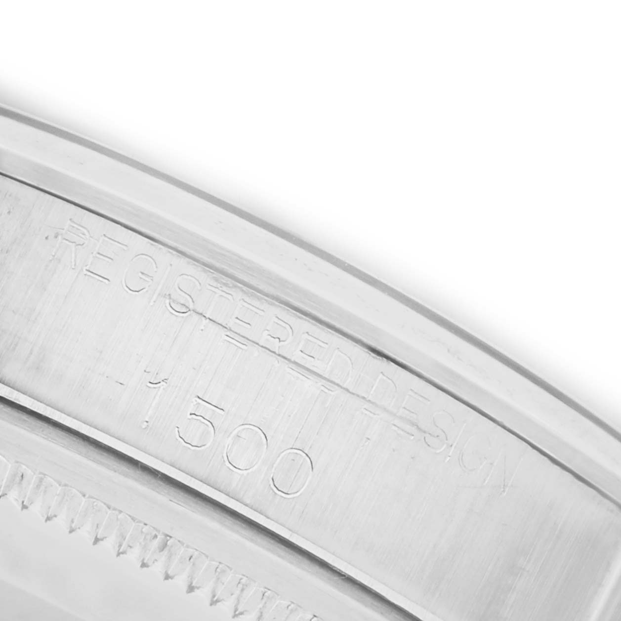 The image shows a close-up of the edge of a Rolex Date 1500 Men's Stainless Steel Grey Dial 1500 Men's Stainless Steel Grey Dial model watch case with engraved text.