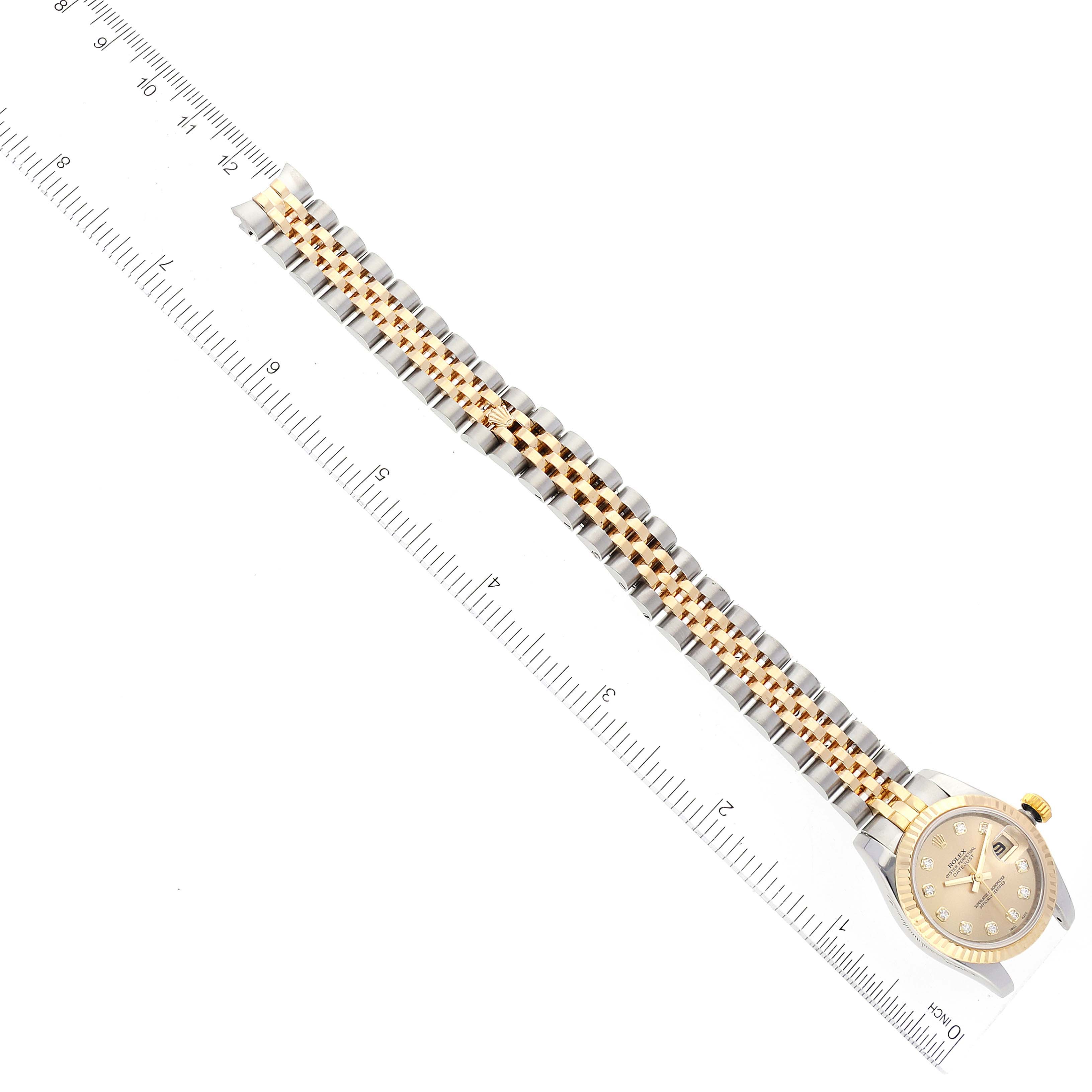 The Rolex Datejust 179173 Women's Steel and Gold (two tone) Champagne Dial 179173 Women's Steel and Gold (two tone) Champagne Dial watch is shown from a top-down view, with a ruler alongside to measure the length of the bracelet.