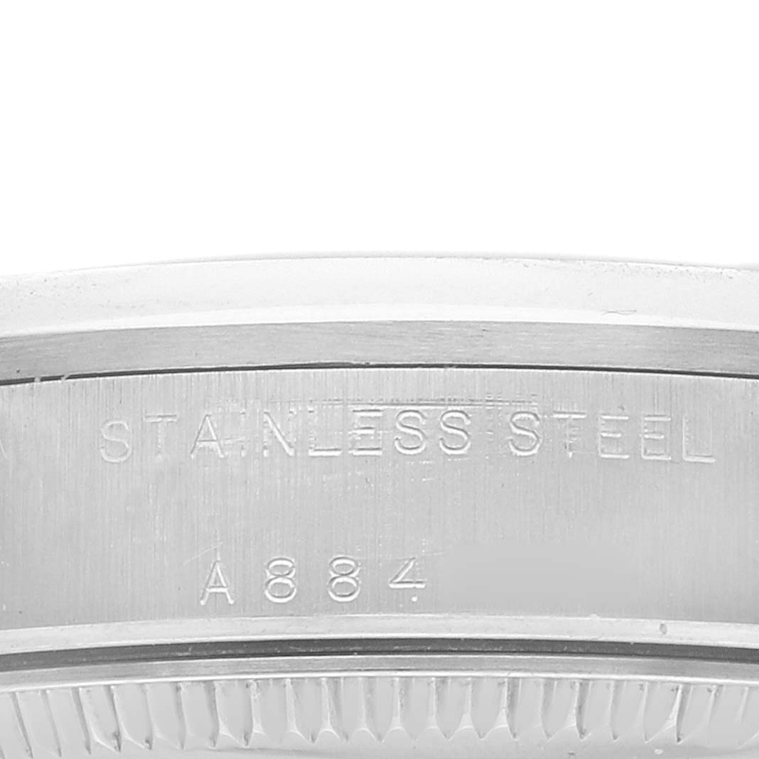 This image shows a close-up of the side of the bezel and case of a mid-size Rolex watch, displaying the "STAINLESS STEEL" inscription and a serial number.