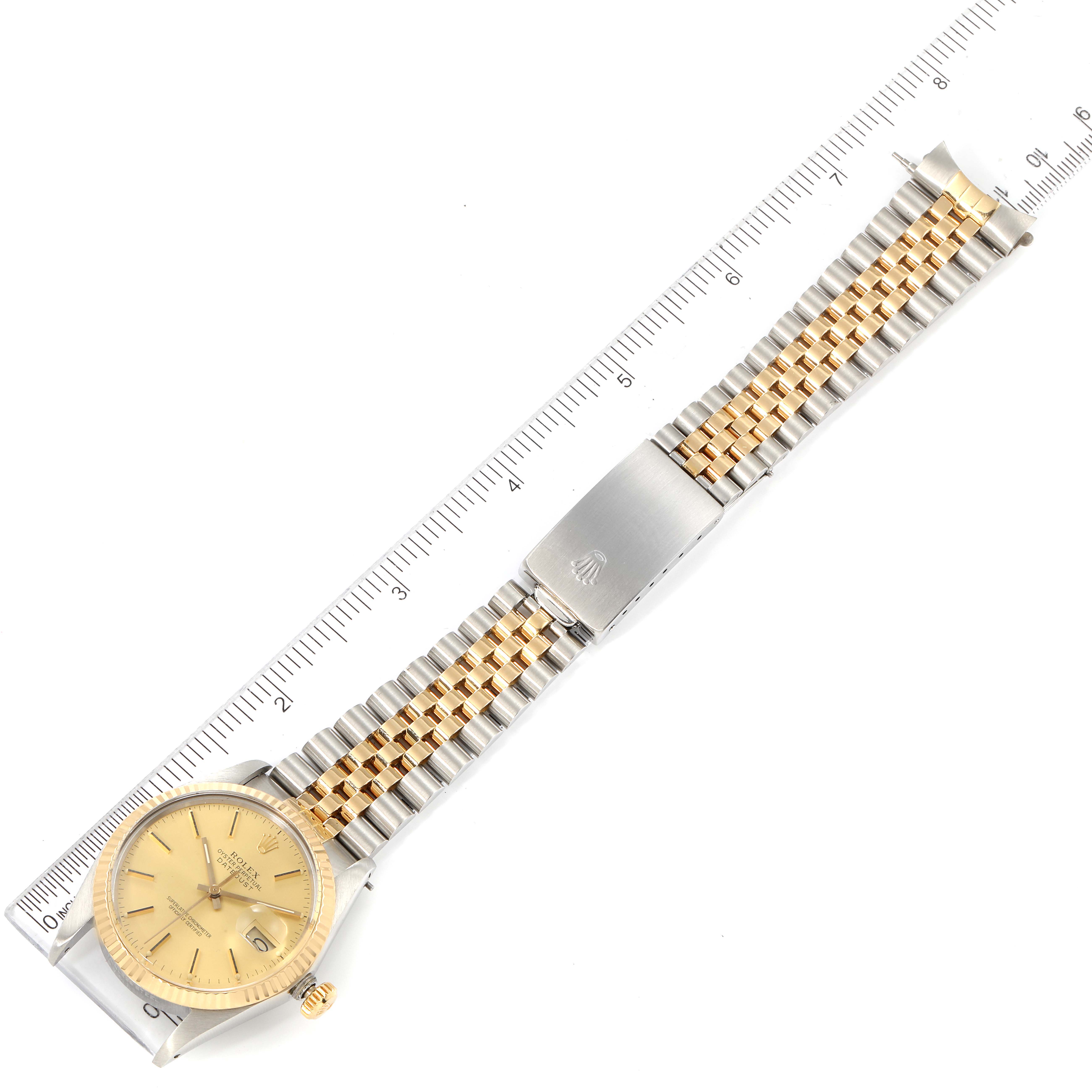 The image shows an overhead view of a Rolex Vintage Collection 16013 Men's Steel and Gold (two tone) Champagne Dial 16013 Men's Steel and Gold (two tone) Champagne Dial watch, displaying its gold and silver band and face alongside a ruler.