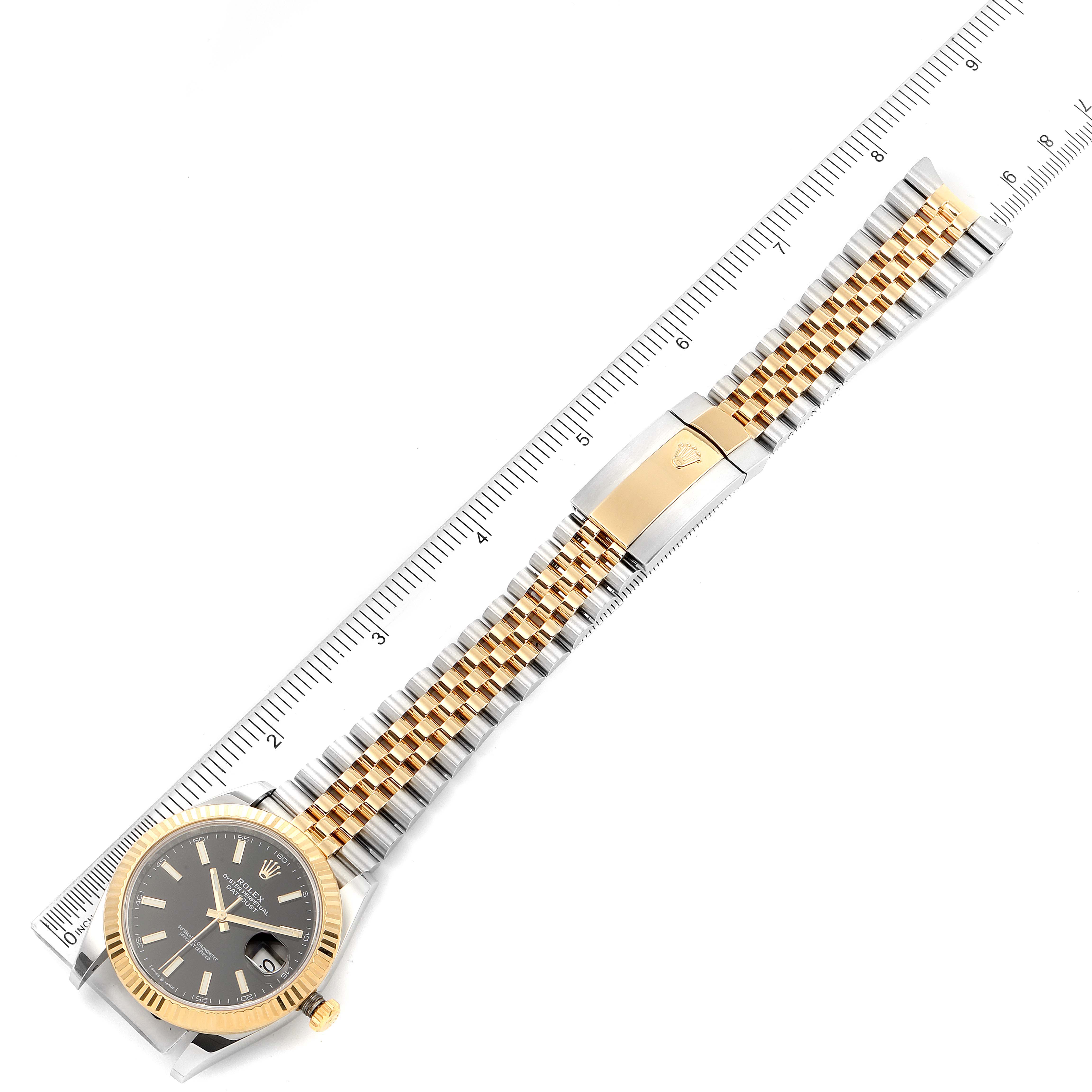 This image shows the Rolex Datejust 41 126333 Men's Steel and Gold (two tone) Black Dial 126333 Men's Steel and Gold (two tone) Black Dial watch, including its face, bezel, crown, Jubilee bracelet, and clasp, positioned next to a ruler.