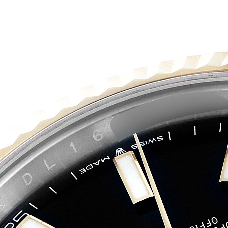 This close-up image of the Rolex Datejust 41 126333 Men's Steel and Gold (two tone) Black Dial 126333 Men's Steel and Gold (two tone) Black Dial watch shows a portion of the dial, hands, and fluted bezel.