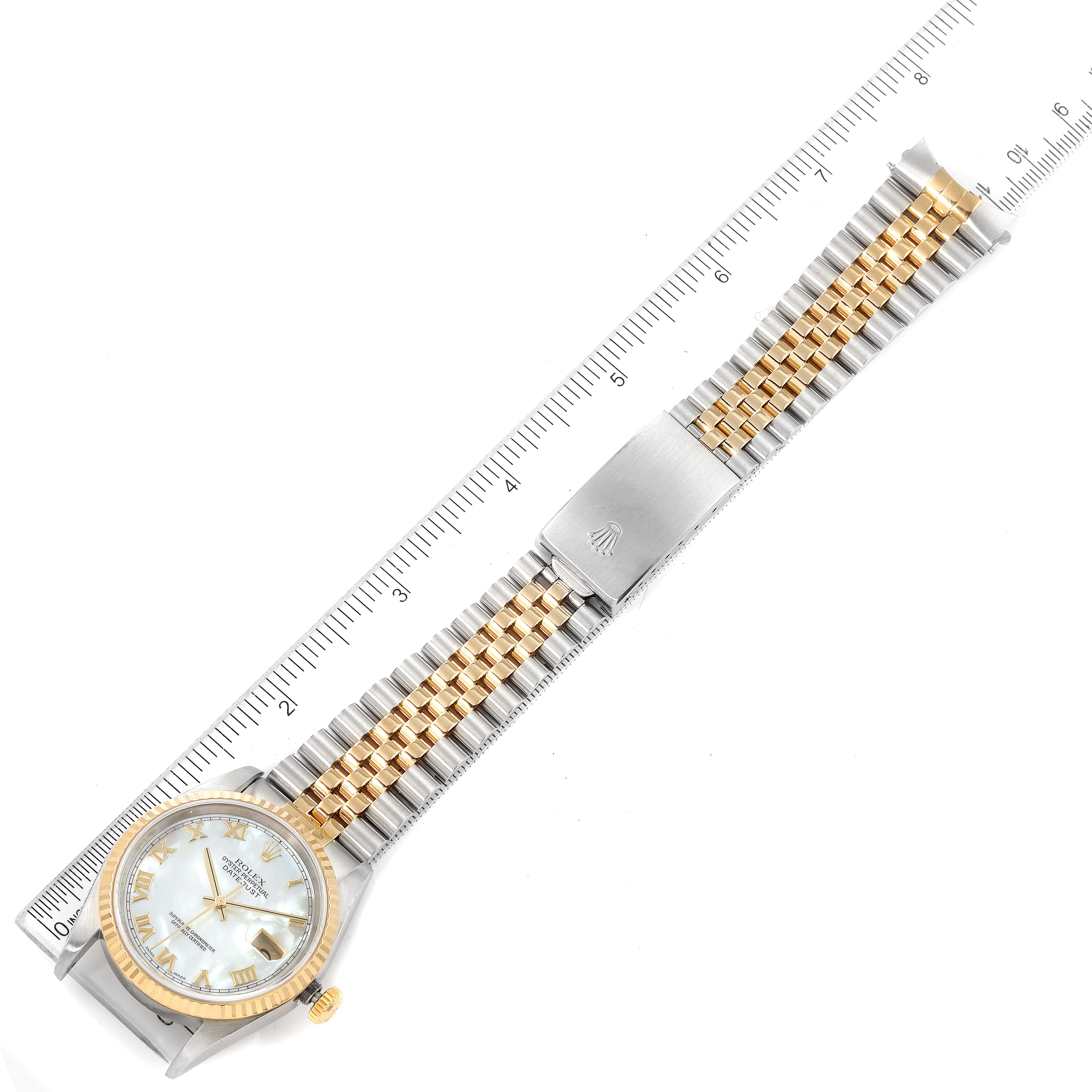 The image shows a top-down view of a Rolex Datejust 16233 Men's Steel and Gold (two tone) Mother of Pearl Dial 16233 Men's Steel and Gold (two tone) Mother of Pearl Dial watch, highlighting its face, band, and clasp alongside a ruler.