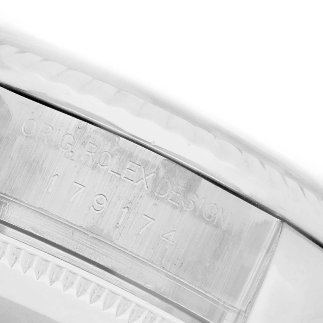 The image shows a close-up of the side engraving on the bezel of a Rolex Datejust 179174 Women's Stainless Steel Blue Dial 179174 Women's Stainless Steel Blue Dial watch.