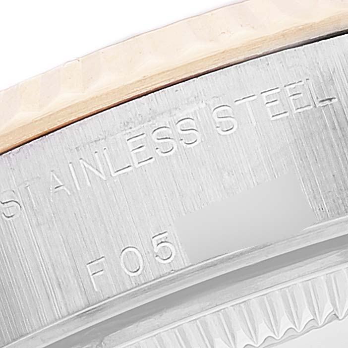 This close-up image shows the engraved "STAINLESS STEEL" text on the side view of the bezel and case of a Rolex Datejust 79173 Women's Steel and Gold (two tone) Beige Dial 79173 Women's Steel and Gold (two tone) Beige Dial watch.