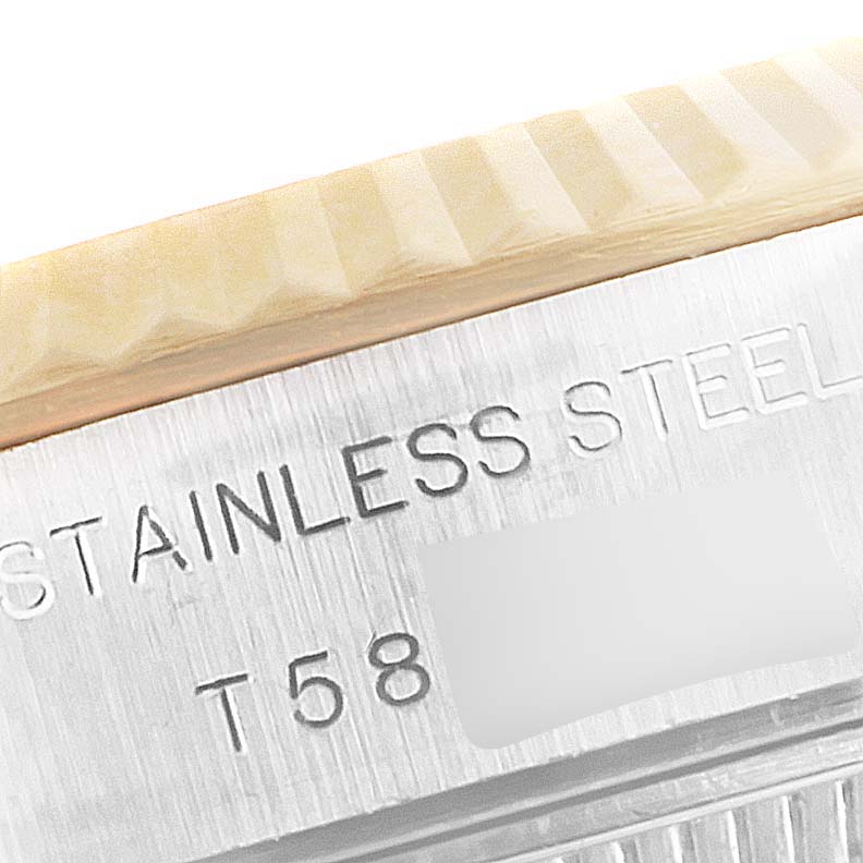 This image shows a close-up of the side of a Rolex Datejust 69173 Women's Steel and Gold (two tone) Silver Dial 69173 Women's Steel and Gold (two tone) Silver Dial watch, focusing on the fluted bezel and "STAINLESS STEEL" engraving.