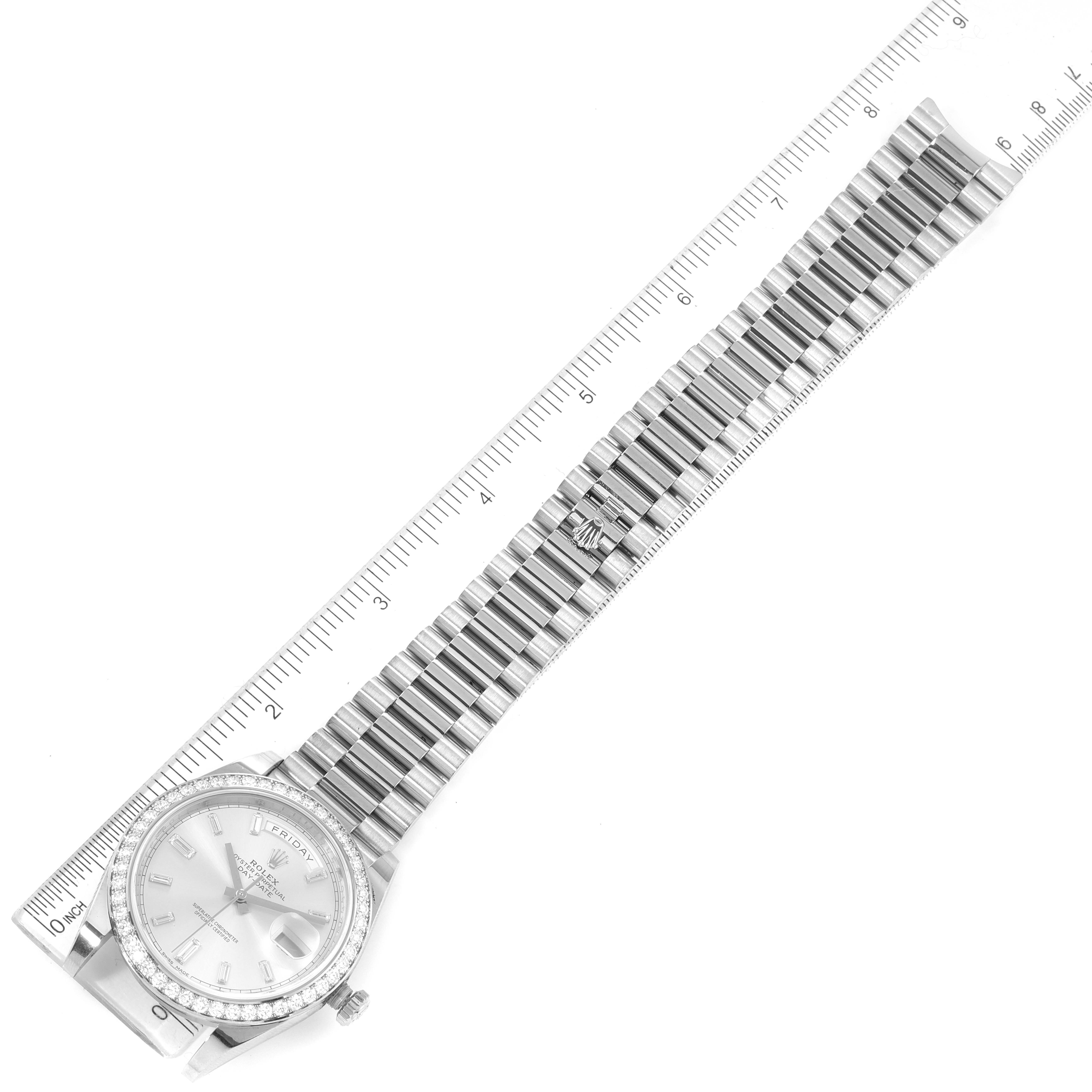 The image shows a Rolex President 228349 Men
s White Gold Silver Dial 228349 Men
s White Gold Silver Dial watch with its face, bracelet, and part of a ruler for size reference.
