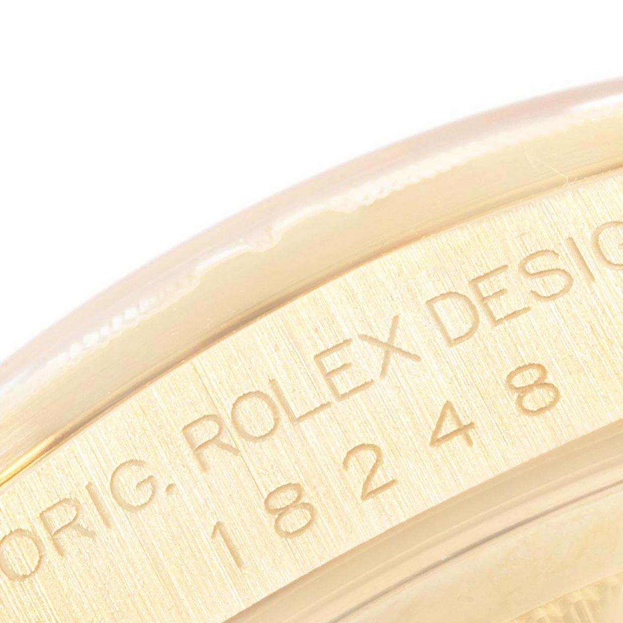 The image shows a close-up of the case edge on a Rolex President 18248 Men
s Yellow Gold Champagne Dial 18248 Men
s Yellow Gold Champagne Dial model, specifically highlighting the engraved model number and "Rolex Design".
