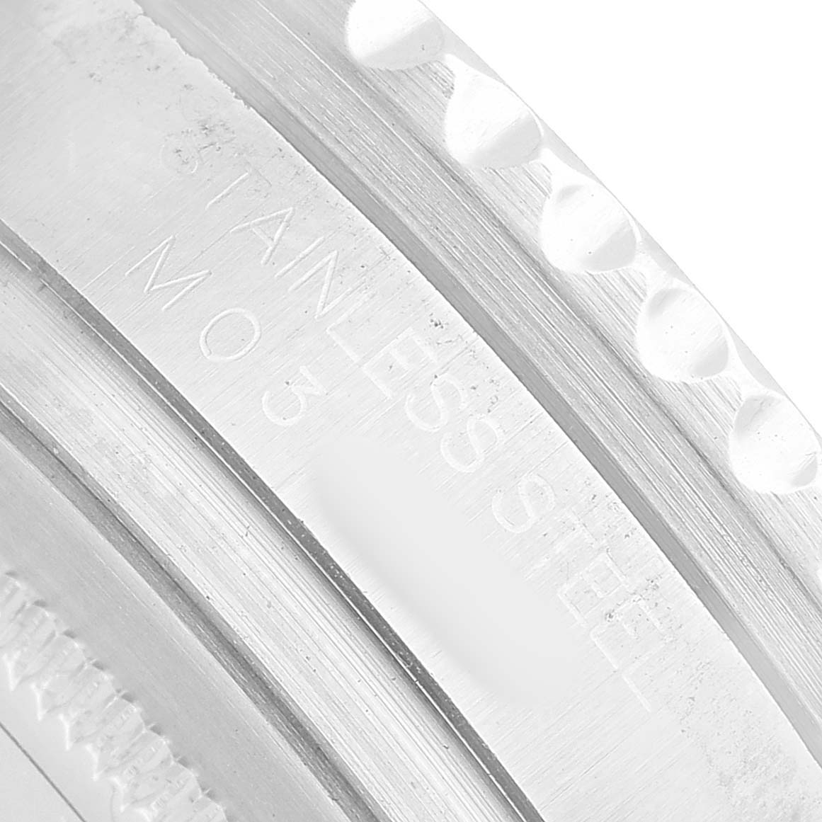 The image shows a close-up of the side engraving on a Rolex GMT-Master 116710 Men's Stainless Steel Black Dial bezel, highlighting "Stainless Steel" text.
