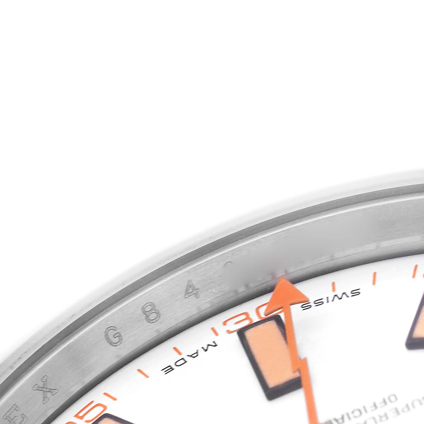The image shows a close-up of a Rolex Milgauss 116400 Men's Stainless Steel White Dial watch, focusing on the dial, orange markers, and bezel lettering.