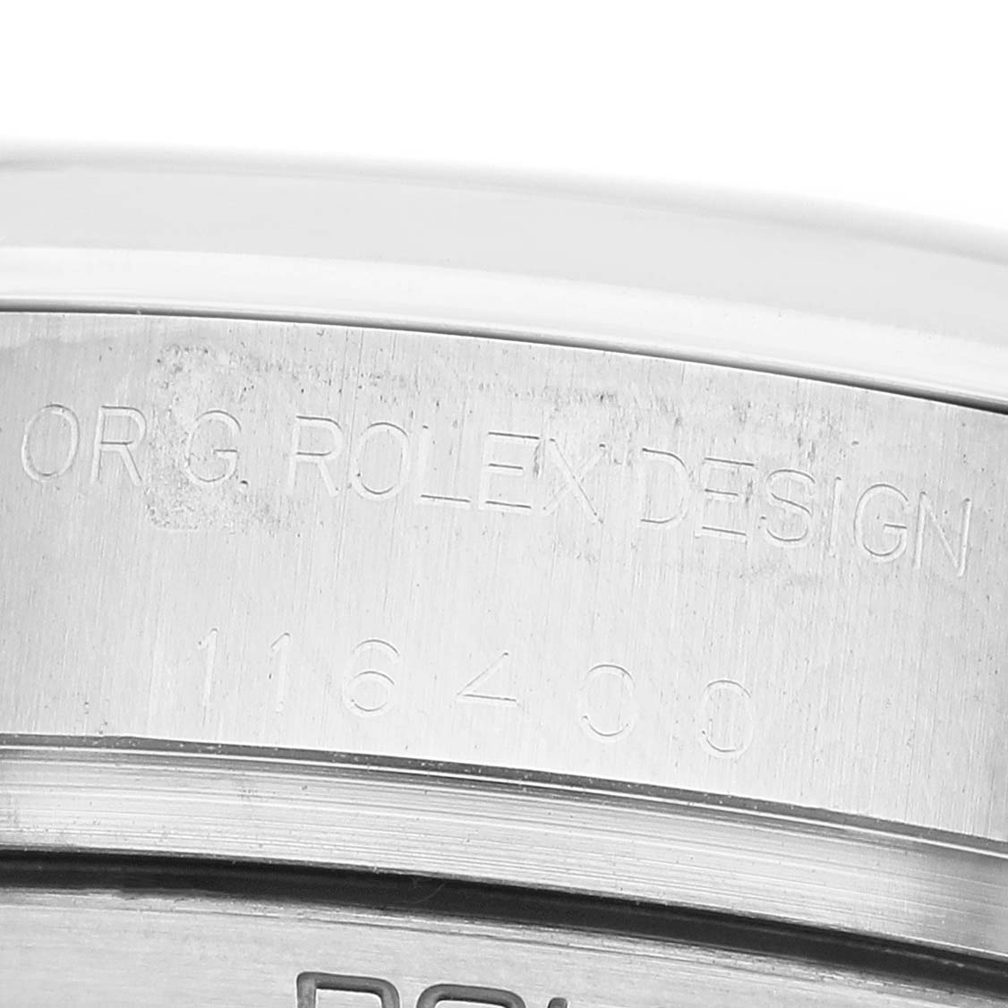 The image shows a close-up of the engraved side of a Rolex Milgauss 116400 Men's Stainless Steel White Dial watch case, displaying the model number.