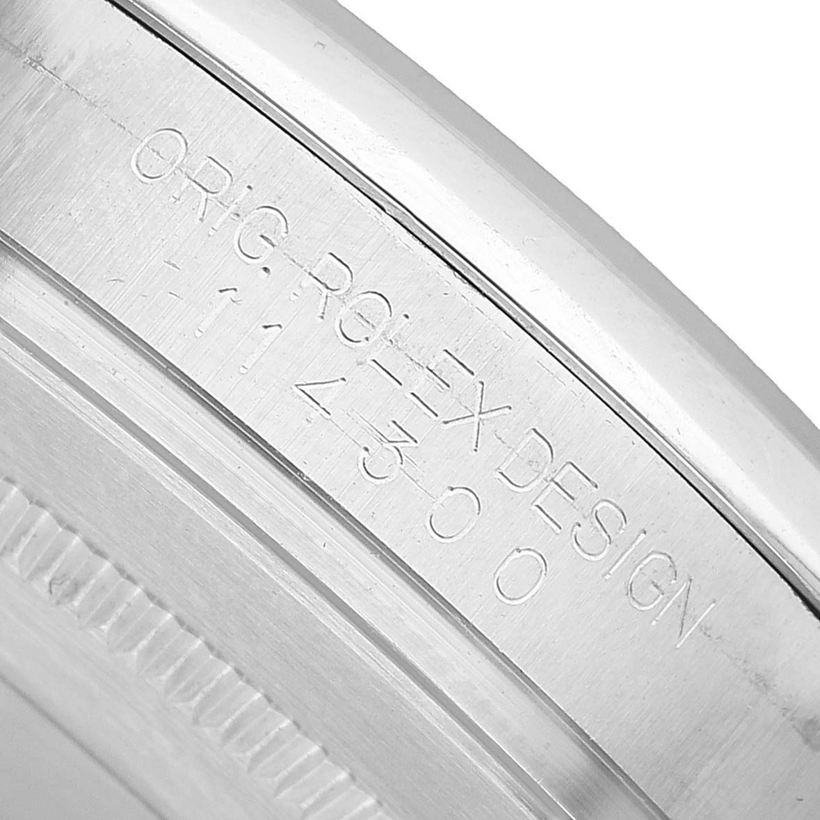 The image shows an inner bezel engraving of the Rolex Oyster Perpetual 114300 Men's Stainless Steel Blue Dial with "ORIG ROLEX DESIGN" and numbers.