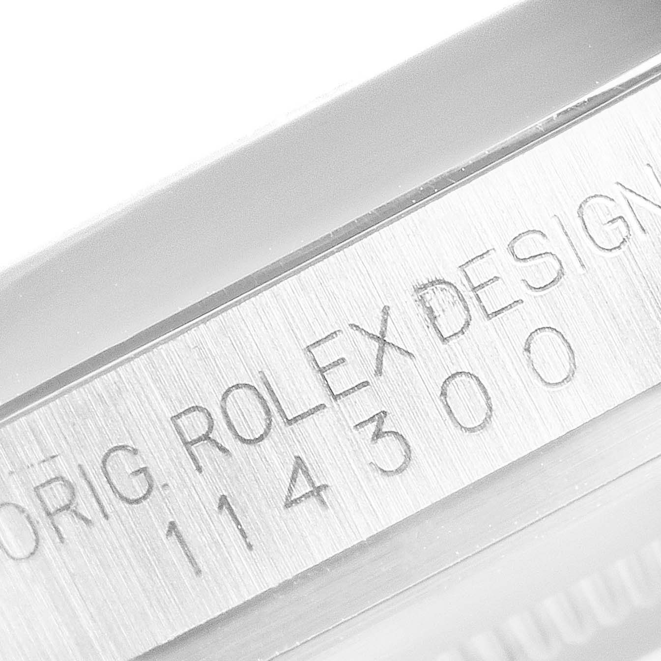 This image shows a close-up of the engraved serial number on the side of a Rolex Oyster Perpetual 114300 Men's Stainless Steel Blue Dial 114300 Men's Stainless Steel Blue Dial watch. 