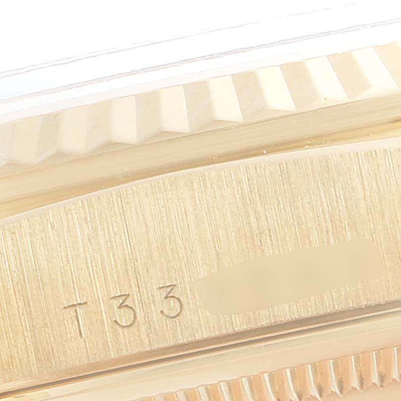 The image shows a close-up of the side of a Rolex President 18238 Men
s Yellow Gold Champagne Dial 18238 Men
s Yellow Gold Champagne Dial model watch, highlighting the bezel and part of the case with some markings.