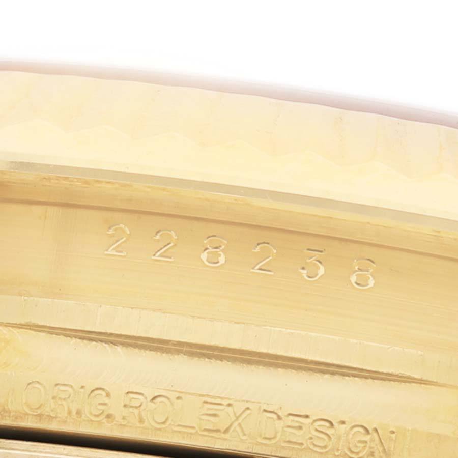 The image shows a close-up of the bezel and engraved serial number on a Rolex President 228238 Men's Yellow Gold Champagne Dial model watch.