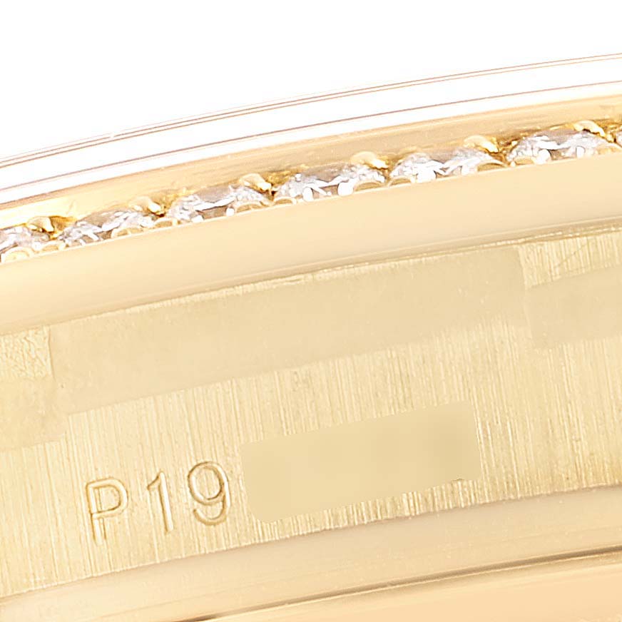 This is a close-up view of the bezel and part of the edge of a Rolex President 118348 Men's Yellow Gold Champagne Dial 118348 Men's Yellow Gold Champagne Dial model watch, showing the serial number engraving and diamond accents.