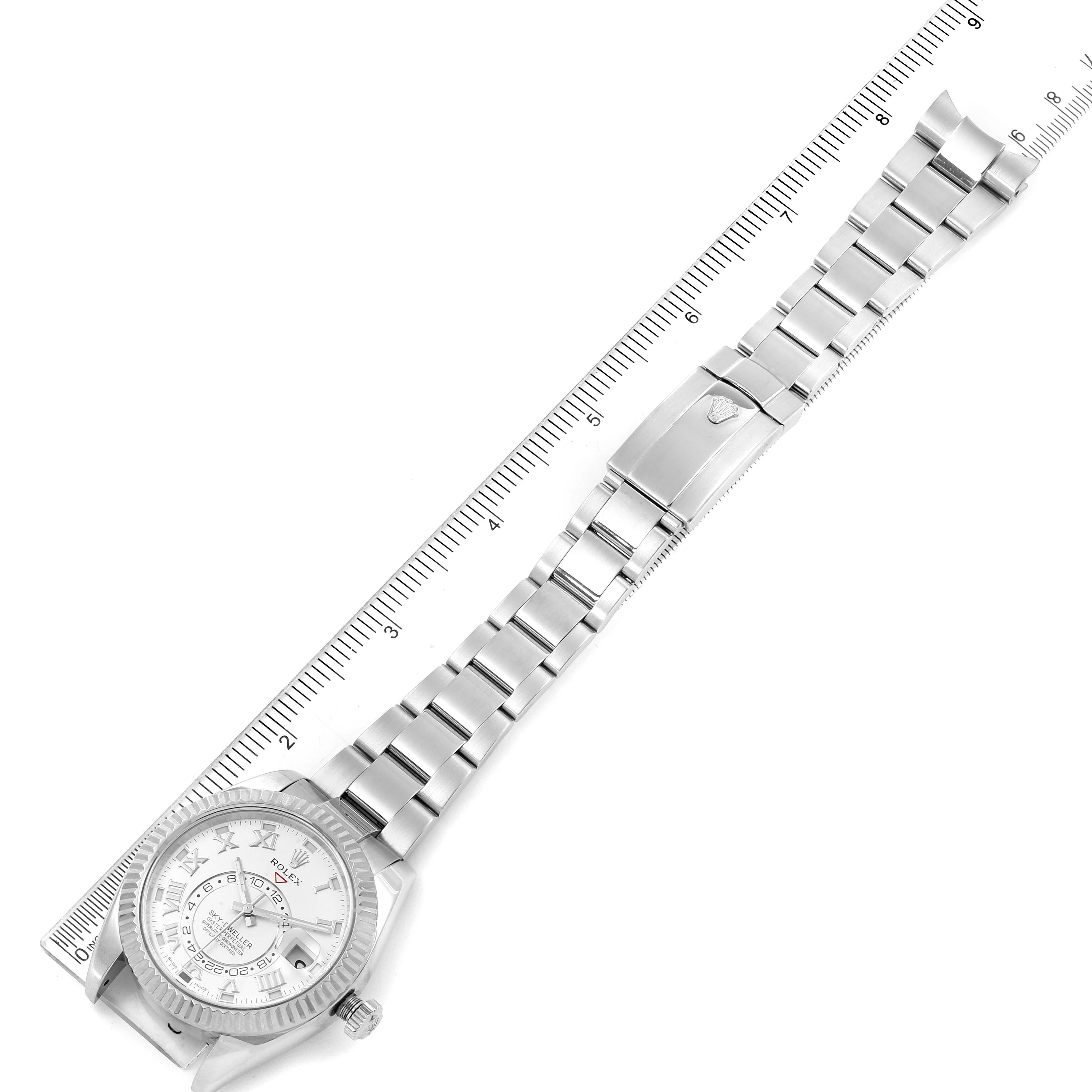 The Rolex Sky-Dweller 326939 Men's White Gold White Dial 326939 Men's White Gold White Dial watch is shown laid flat with a ruler for scale, displaying the dial, bezel, and bracelet.