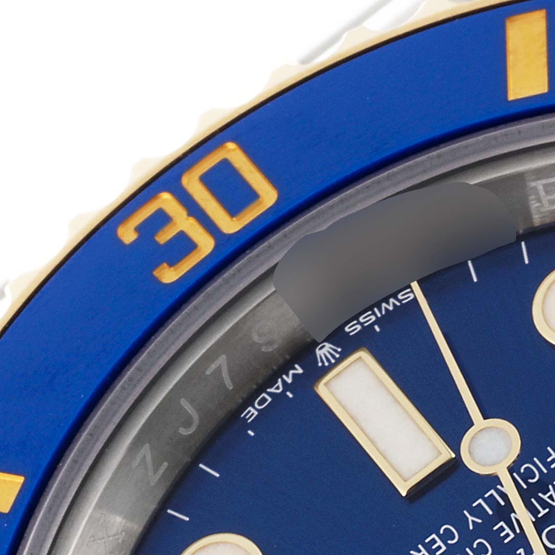 The close-up image shows the bezel and part of the dial of a Rolex Submariner 126613 Men's Steel and Gold (two tone) Blue Dial 126613 Men's Steel and Gold (two tone) Blue Dial watch, featuring a blue and gold color scheme.