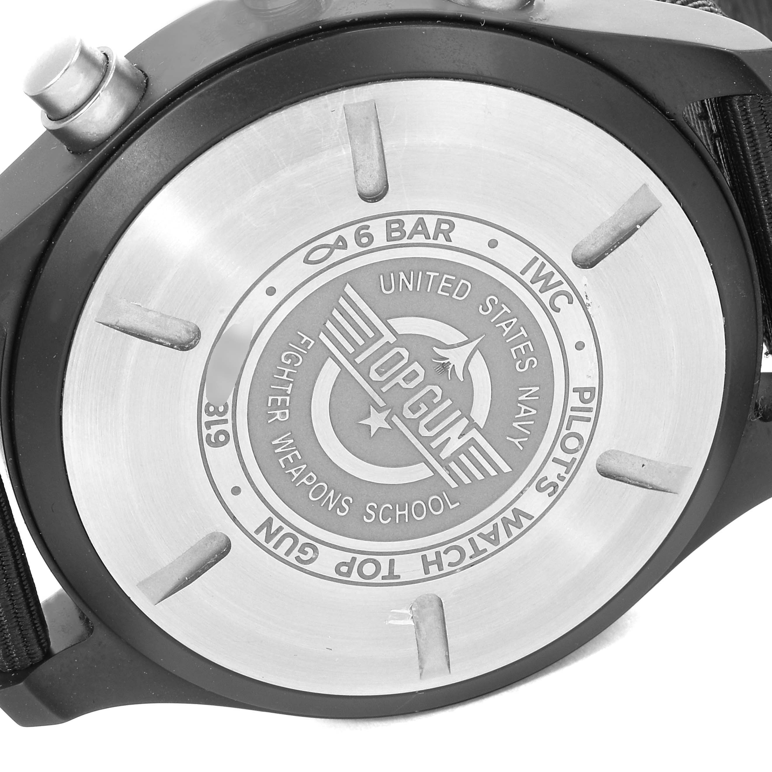 The image shows the back case of an IWC Pilot IW389101 Men
s Titanium Black Dial IW389101 Men
s Titanium Black Dial
s Watch, model "Top Gun," with engravings and a portion of the strap.