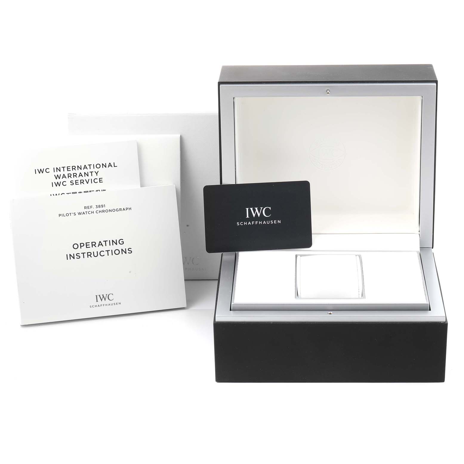 The image shows the IWC Pilot IW389101 Men
s Titanium Black Dial IW389101 Men
s Titanium Black Dial watch
s open box, warranty and service booklets, operating instructions, and a black IWC card.
