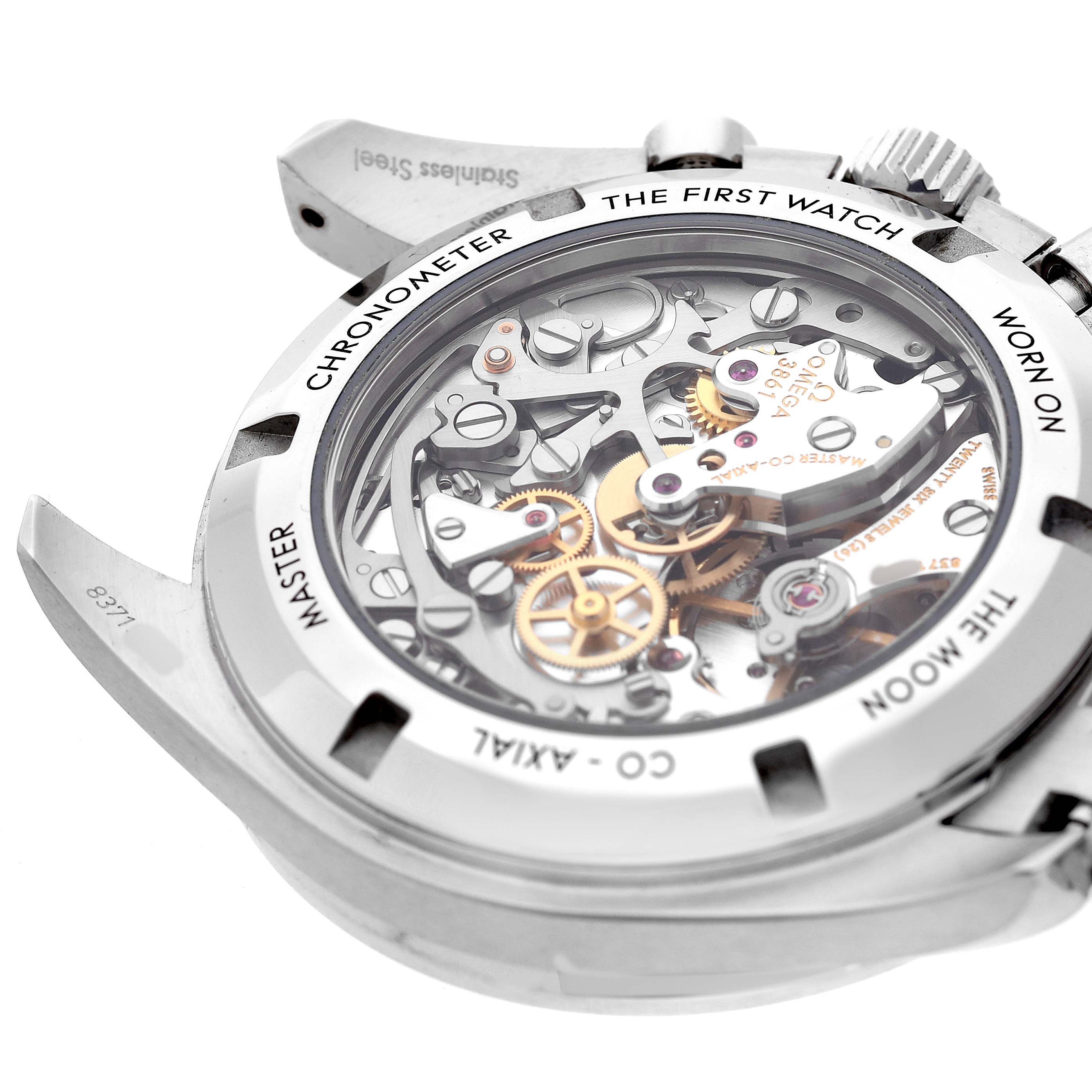 The Omega Speedmaster 310.30.42.50.01.002 Men's Stainless Steel Black Dial watch is shown from the back, revealing intricate mechanical movement and inscriptions on the case back.